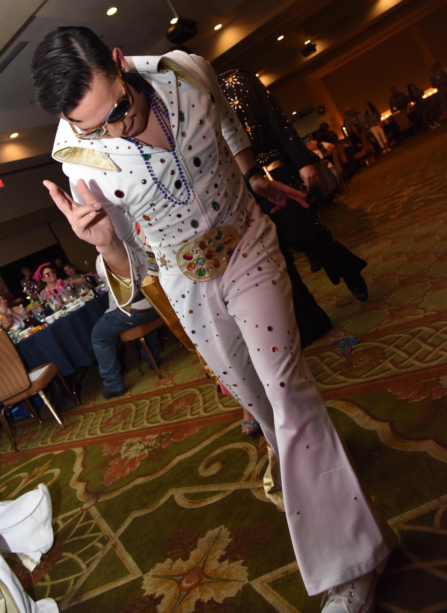 Tech. Sgt. Randal Hernandez, 81st Training Wing command chief executive, portrays Elvis Presley during a costume contest at the 29th Annual Krewe of Medics Mardi Gras Ball at the Bay Breeze Event Center Jan. 28, 2017, on Keesler Air Force Base, Miss. The Krewe of Medics hosts a yearly ball to give Keesler Medical Center personnel a taste of the Gulf Coast and an opportunity to experience a traditional Mardi Gras. The theme for this year's ball was Blast From The Past. (U.S. Air Force photo by Kemberly Groue)