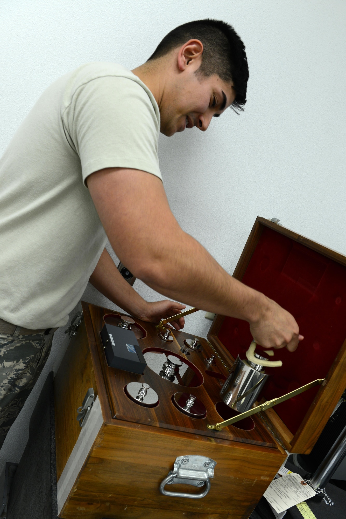 Senior Airman Donald Area, 56th Component Maintenance Squadron precision measurement equipment laboratory technician, lifts class 1 weights with prongs for a simulated weight measurement Jan. 24, 2017, at Luke Air Force Base, Ariz. The high accuracy weights are used to calibrate high accuracy scales.(U.S. Air Force photo by Airman 1st Class Pedro Mota)