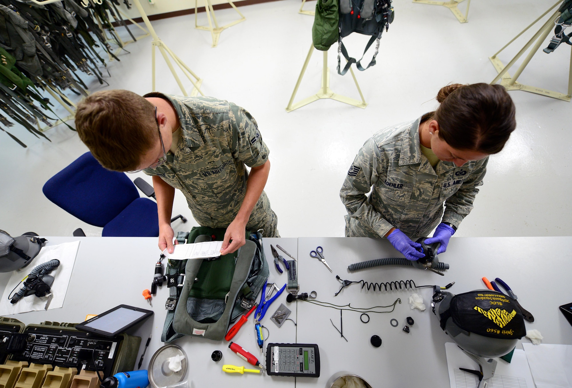 U.S. Air Force Tech. Sgt. Suzanne Koehler, an aircrew flight equipment technician assigned to the 131st Operations Support Flight, and Airman 1st Class Timothy Doyle, an aircrew flight equipment apprentice assigned to the 509th Operations Support Squadron, take apart aircrew equipment to ensure all components are correctly functioning at Andersen Air Force Base, Guam, Jan. 24, 2017. Bomber missions familiarize aircrew with airbases and operations in different Geographic Combatant Commands. (U.S. Air Force photo by Airman 1st Class Jazmin Smith)
