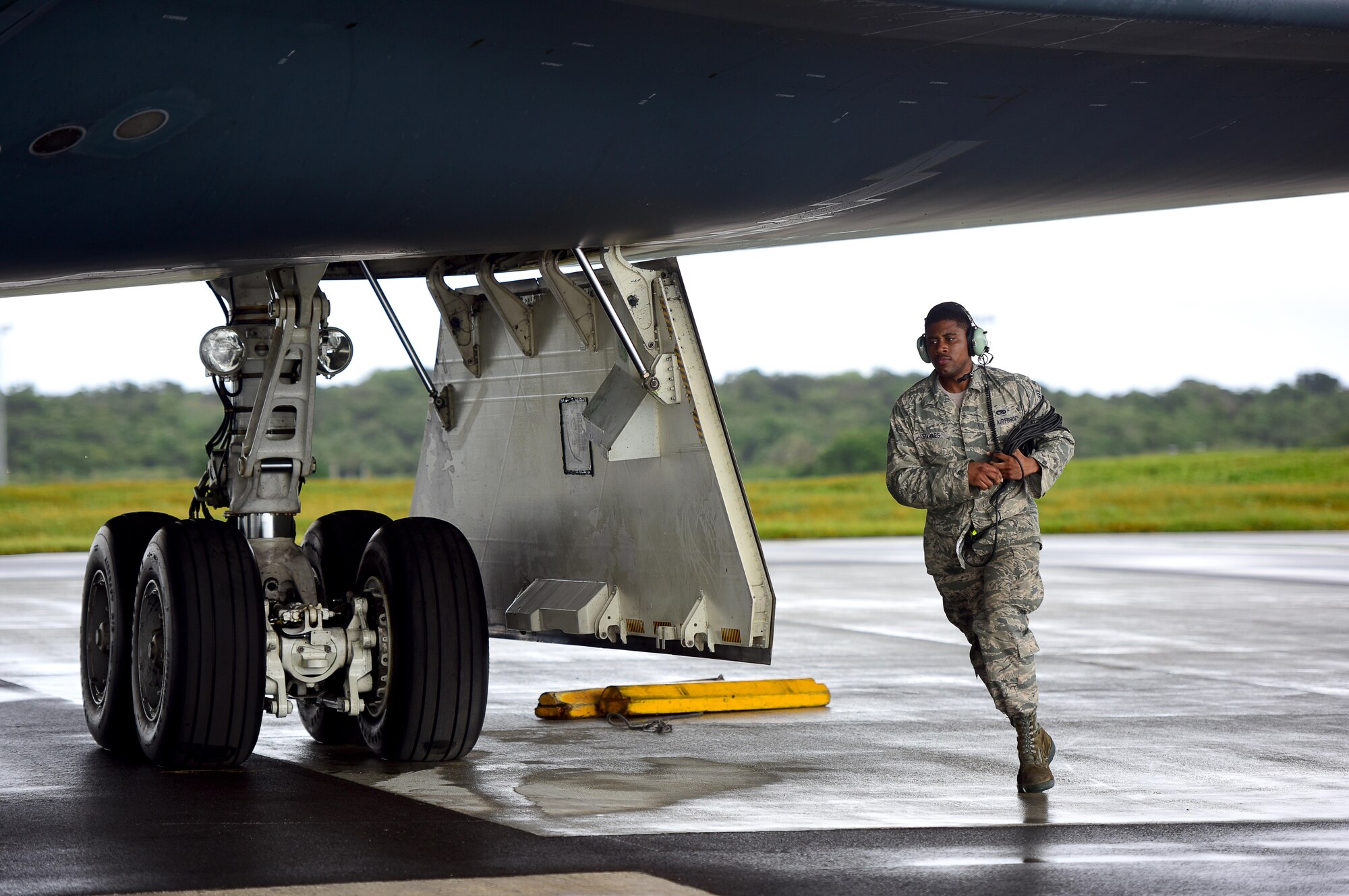 U.S. Air Force Senior Airman Dez Starkes, a crew chief assigned to the 509th Aircraft Maintenance Squadron, runs to the other side of a B-2 Spirit to remove chocks from the wheels prior to takeoff at Andersen Air Force Base, Guam, Jan. 12, 2017. Strategic bomber missions enhance the readiness and training necessary to respond to any potential crisis or challenge across the globe. (U.S. Air Force photo by Airman 1st Class Jazmin Smith)