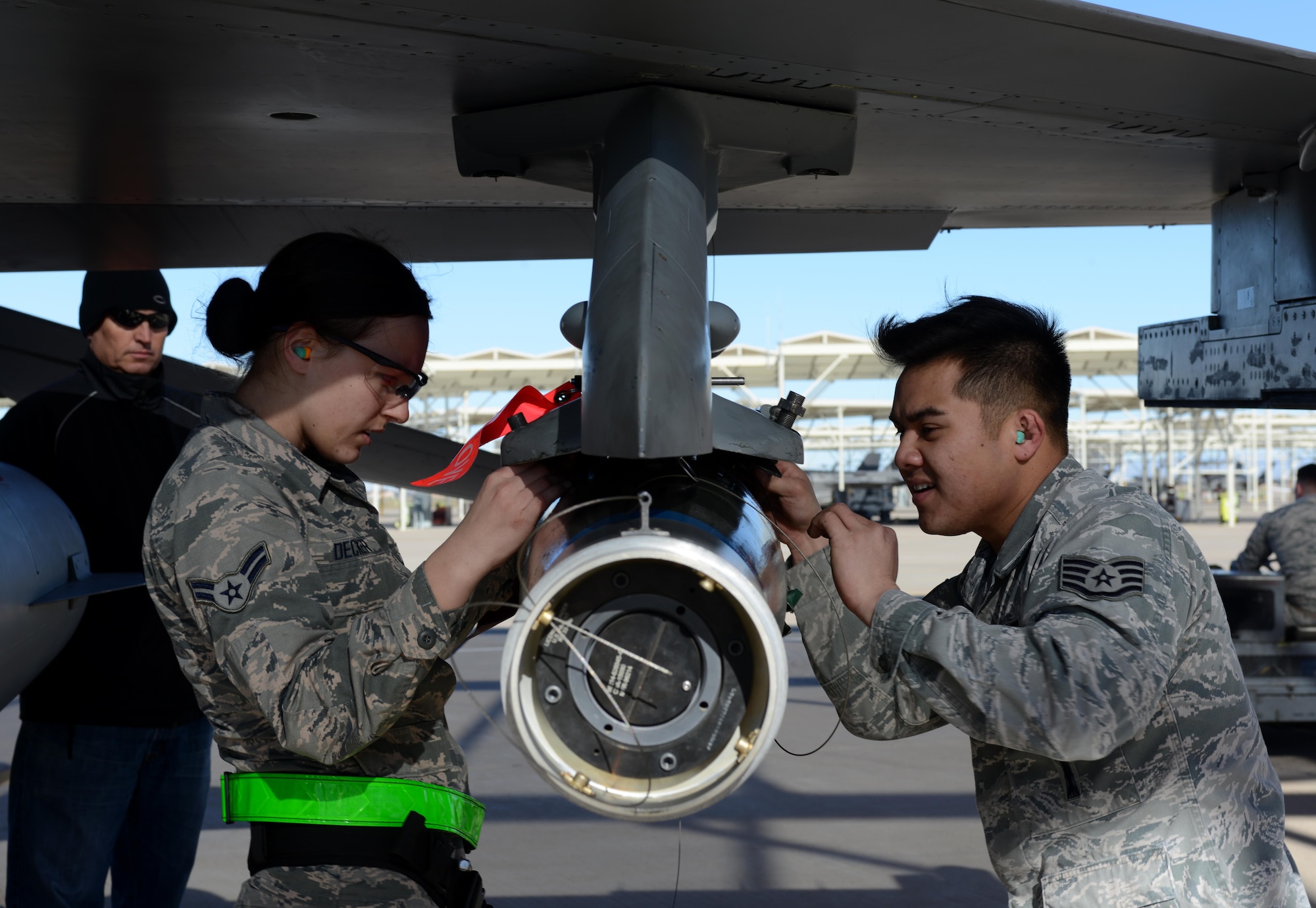 Airman 1st Class Kathryn Decker, 310th Aircraft Maintenance Unit weapons load team member, and Staff Sgt. Dranel David 310th AMU weapons standardization load crew member, load a GBU-12 bomb during the annual Load Crew Competition Jan. 27, 2017, at Luke Air Force Base, Ariz. The competition is held to strengthen readiness, enhance communication and build teamwork through friendly competition. (U.S. Air Force photo by Airman 1st Class Alexander Cook)