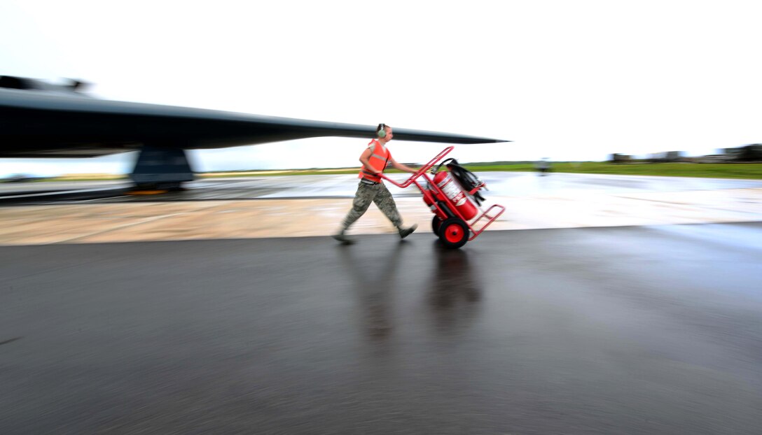 U.S. Air Force Senior Airman Richard Huartson, a crew chief assigned to the 509th Aircraft Maintenance Squadron, walks the fire extinguisher off the parkway prior to a U.S. Air Force B-2 Spirit aircraft takeoff at Andersen Air Force Base, Guam, Jan. 12, 2017. Close to 200 Airmen from Whiteman Air Force Base, Mo., and Barksdale Air Force Base, La., deployed to Andersen AFB, in support of U.S. Strategic Command Bomber and Deterrence missions. USSTRATCOM bomber missions familiarize aircrew with airbases and operations in different Geographic Combatant Commands. (U.S. Air Force photo by Tech. Sgt. Andy M. Kin)