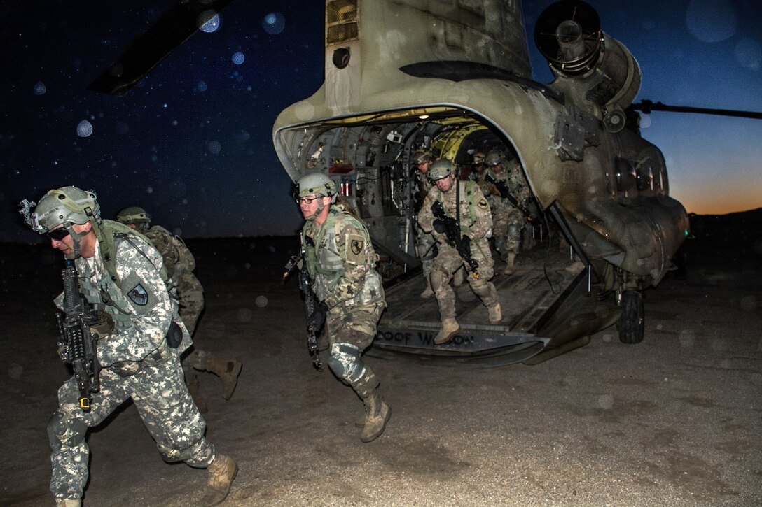 Soldiers disembark from a CH-47 Chinook helicopter to establish a defensive perimeter before participating in an air assault training exercise at the National Training Center, Fort Irwin, Calif., Jan. 25, 2017. Army photo by Pvt. Austin Anyzeski