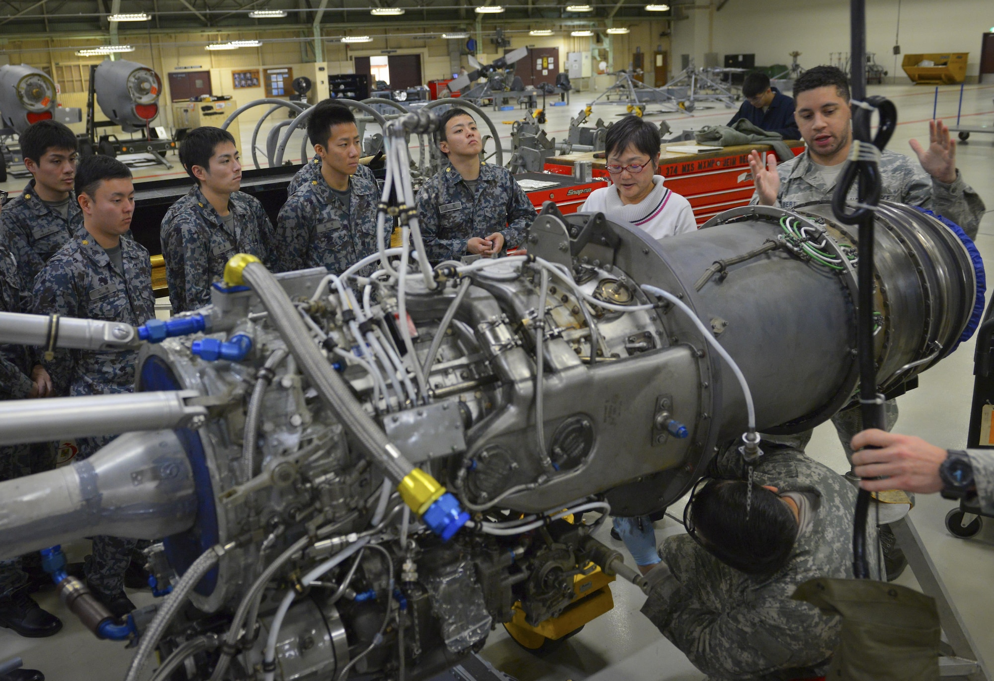 Staff Sgt. Synard Bert, 374th Maintenance Squadron propulsion flight propulsion journeyman, explains the structure of a C-130H Hercules engine to Japan Air Self Defense Force maintenance officers-in-training at Yokota Air Base, Japan, Jan. 25, 2017. The officers-in-training learned about how Yokota maintenance works in order to strengthen ties and improve bilateral operations. (U.S. Air Force photo by Senior Airman Elizabeth Baker)