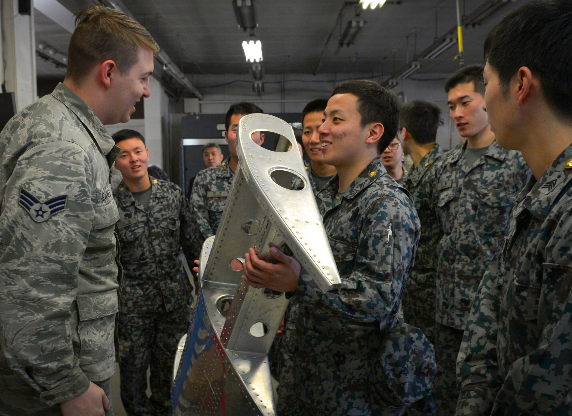 Senior Airman Nicholas Barnes, 374th Maintenance Squadron fabrication flight aircraft structural journeyman, shows a demonstration piece to Japan Air Self Defense Force maintenance officers-in-training at Yokota Air Base, Japan, Jan. 25, 2017. The officers-in-training interacted with Yokota Airmen, asked questions and witnessed firsthand how maintenance operates at Yokota. Interactive bilateral visits are designed to strengthen Japan-U.S. relations and improve how they operate together. (U.S. Air Force photo by Senior Airman Elizabeth Baker)