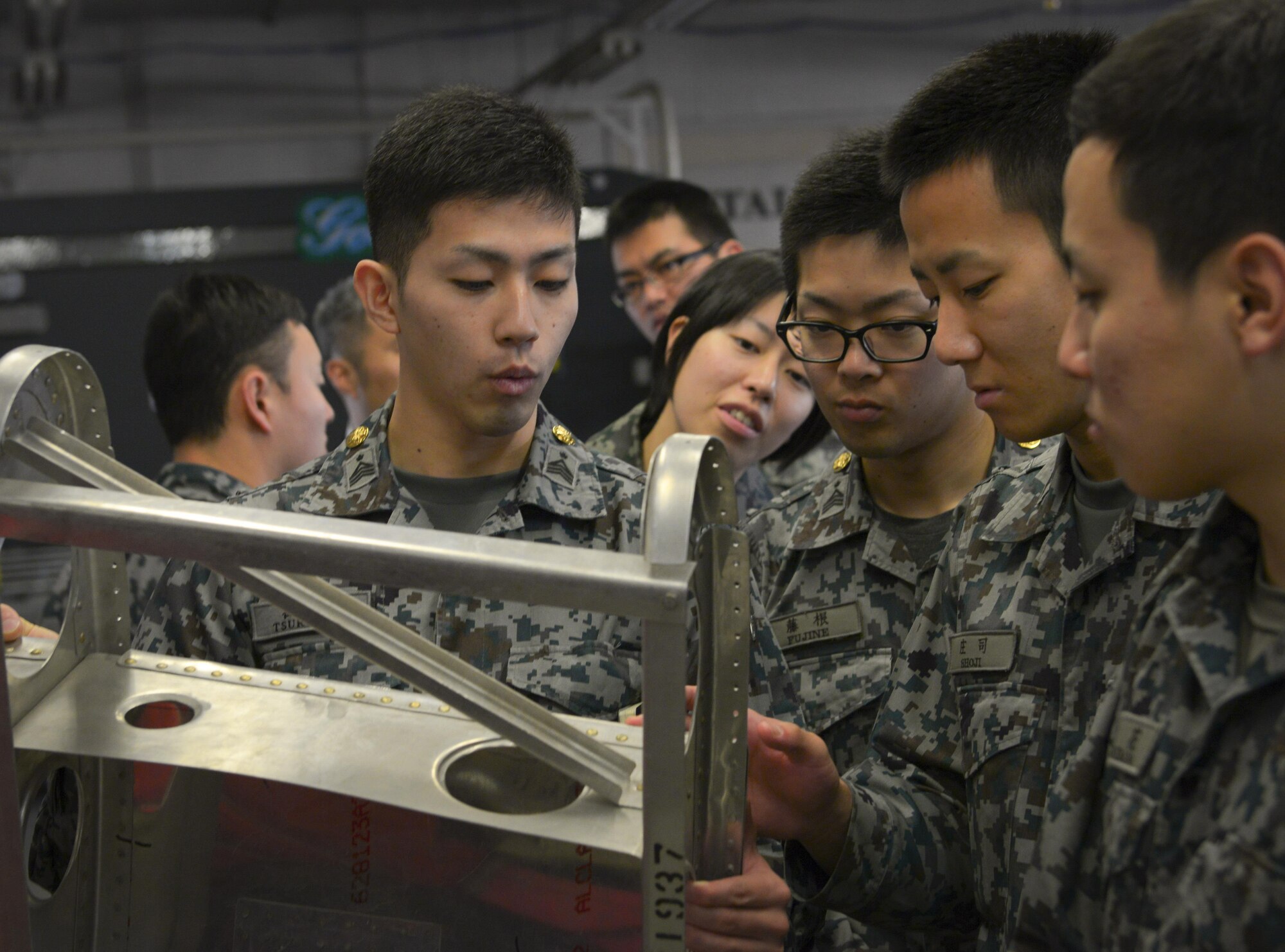 Japan Air Self Defense Force maintenance officers-in-training observe a demonstration piece at the 374th Maintenance Squadron fabrication flight at Yokota Air Base, Japan, Jan. 25, 2017. The JASDF officers visited Yokota maintenance shops, spoke with personnel and observed operations in order to understand and learn from their differences. Interactive bilateral visits are designed to strengthen Japan-U.S. relations and improve how they operate together. (U.S. Air Force photo by Senior Airman Elizabeth Baker)