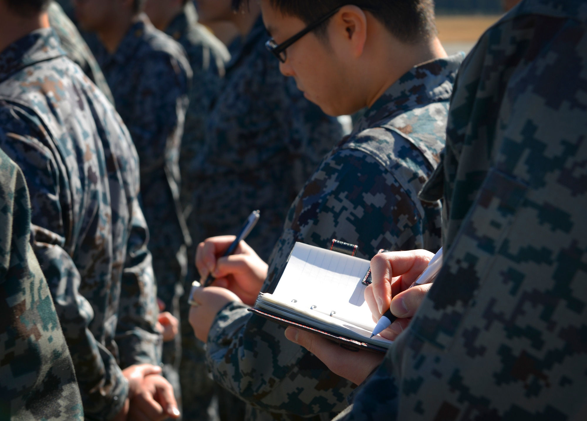 Japan Air Self Defense Force maintenance officers-in-training take notes as a 374th Aircraft Maintenance Squadron member explains his job at Yokota Air Base, Japan, Jan. 25, 2017. The JASDF officers visited Yokota maintenance shops and discovered how Yokota MXG operates in order to understand and learn from their differences. Interactive bilateral visits are designed to strengthen Japan-U.S. relations and improve how we operate together. (U.S. Air Force photo by Senior Airman Elizabeth Baker)
