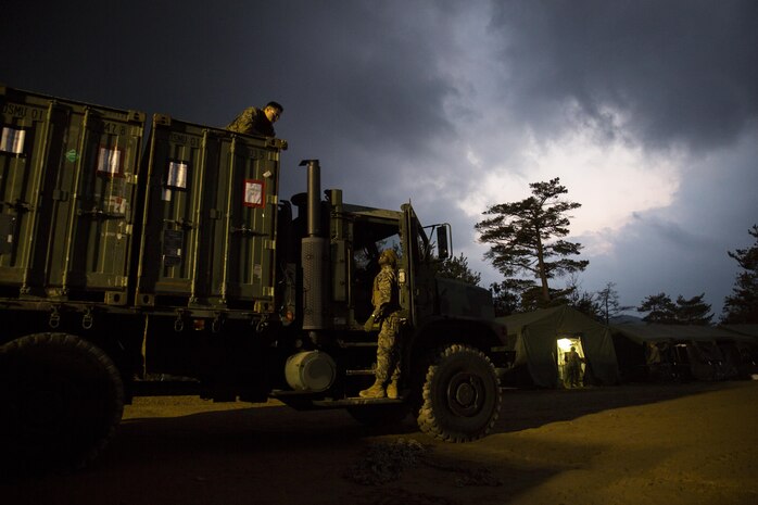 U.S. Marines with Marine Wing Support Squadron 171 communicate to each other after loading quadcon shipping containers onto a seven-ton medium tactical vehicle replacement during exercise Kamoshika Wrath 17-1 at Haramura Maneuver Area, Hiroshima, Japan, Jan. 27, 2017. The Marines worked through inclement weather conditions and a short timeline to build a 96-foot by 96-foot vertical takeoff and landing pad. The exercise is a biannual, unit-level training exercise that is primarily focused on establishing a forward operating base and providing airfield operation services. MWSS-171 trains throughout the year completing exercises like Kamoshika Wrath to enhance their technical skills, field experience and military occupational specialty capability. (U.S. Marine Corps photo by Cpl. Donato Maffin)