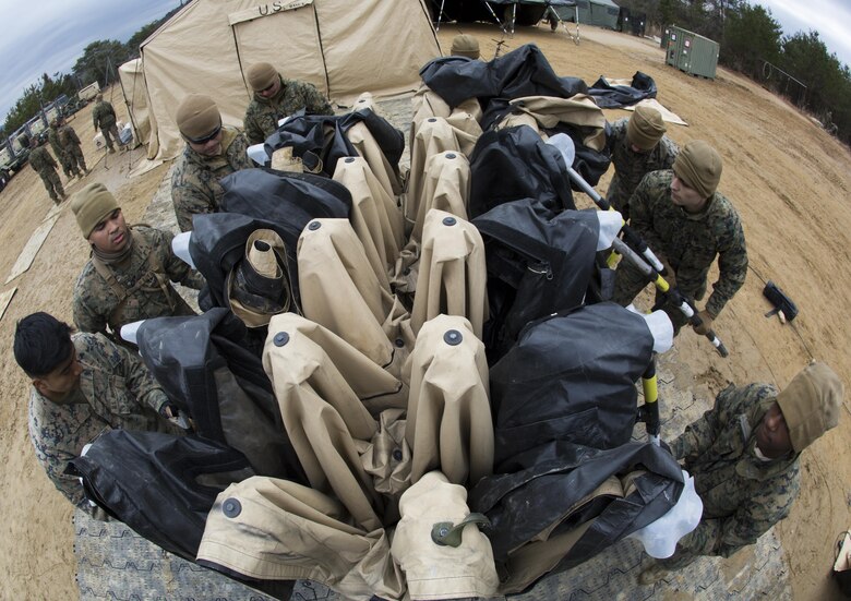 U.S. Marines with Marine Wing Support Sqaudron 171 fold a 305 tent during exercise Kamoshika Wrath 17-1 at Haramura Maneuver Area, Hiroshima, Japan, Jan. 27, 2017. The Marines worked through inclement weather conditions and a short timeline to build a 96-foot by 96-foot vertical takeoff and landing pad. The exercise is a biannual, unit-level training exercise that is primarily focused on establishing a forward operating base and providing airfield operation services. MWSS-171 trains throughout the year completing exercises like Kamoshika Wrath to enhance their technical skills, field experience and military occupational specialty capability. (U.S. Marine Corps photo by Cpl. Donato Maffin)