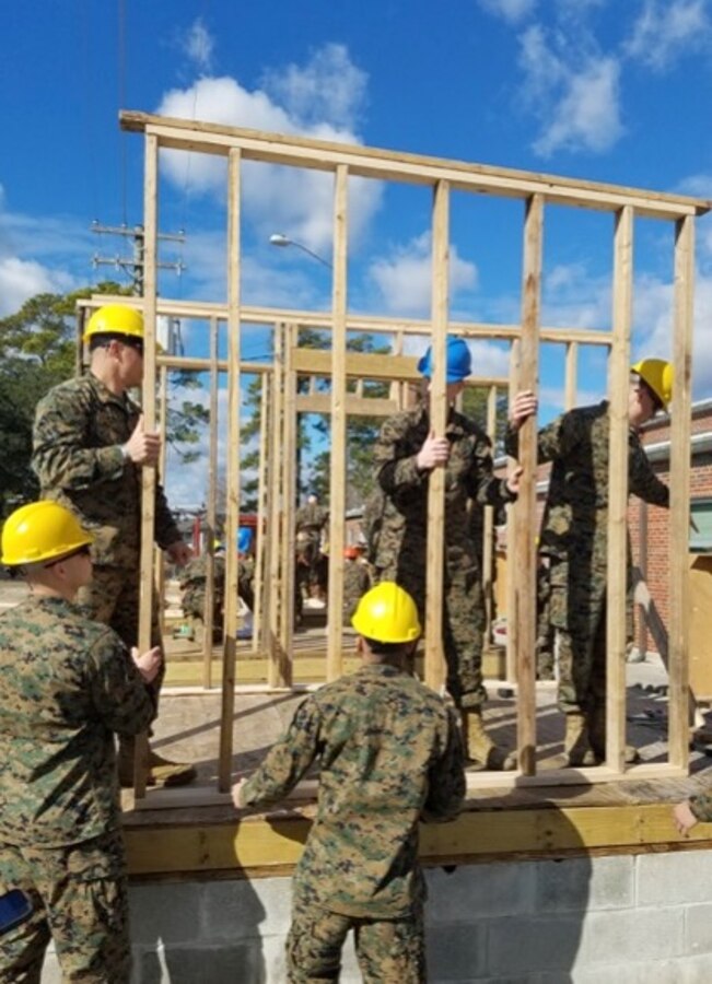 On January 24, 2017 at Courthouse Bay, Camp Lejeune, N.C., Marines attached to Combat Engineer Officer course 2-17 (CEO 2-17) install a prefabricated wood frame wall as part of the practical application portion of their lesson on vertical construction. CEO students learn how to plan and construct single-story structures during this period of instruction.  Pictured from left to right are Second Lieutenants Wesley Rathwick, Chase Alexanian, Carlos Perez, Cody Murphy, and Mitchell Bottini.
