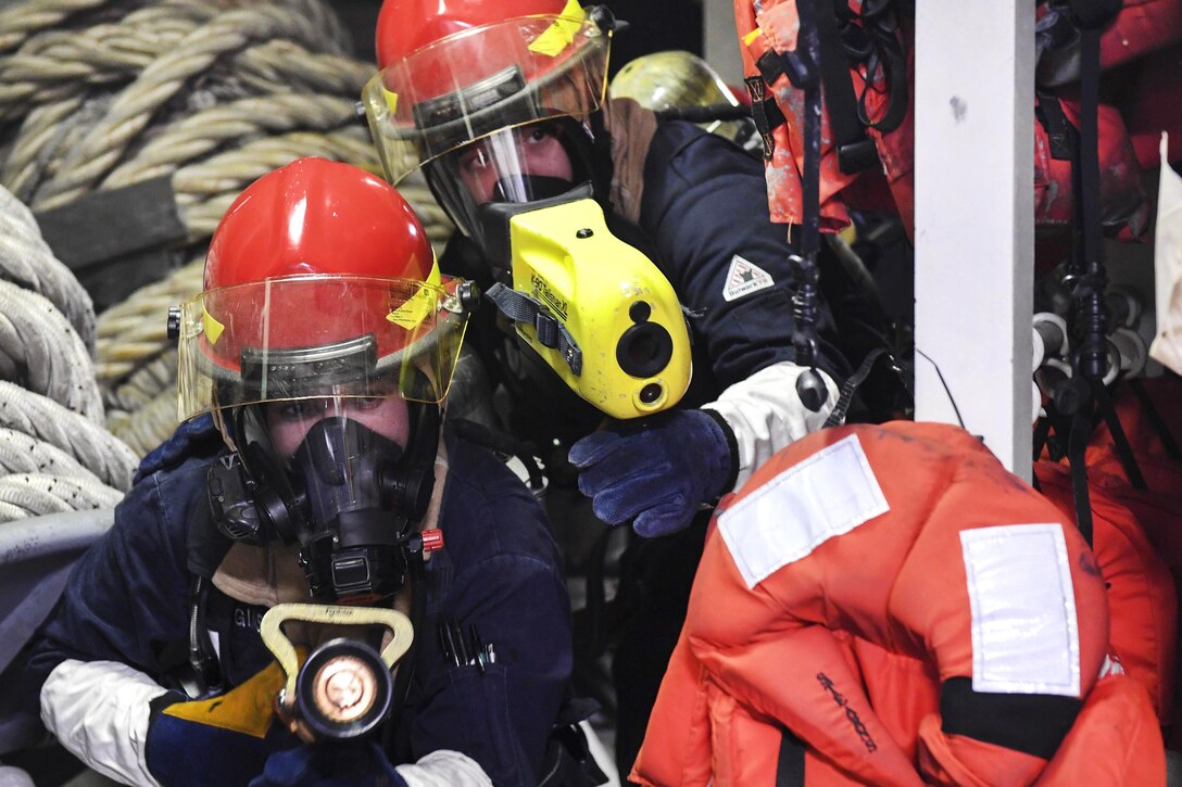 Navy Seaman Nicolas Higgins, left, simulates spraying water on a simulated fire as Navy Seaman Ari Rauda uses a thermal imaging system during a fire drill aboard Arleigh Burke-class guided-missile destroyer USS Wayne E. Meyer in the Pacific Ocean, Jan. 25, 2017. Higgins is a machinery repairman fireman and Rauda is a damage controlman fireman. Navy photo by Petty Officer 3rd Class Kelsey L. Adams