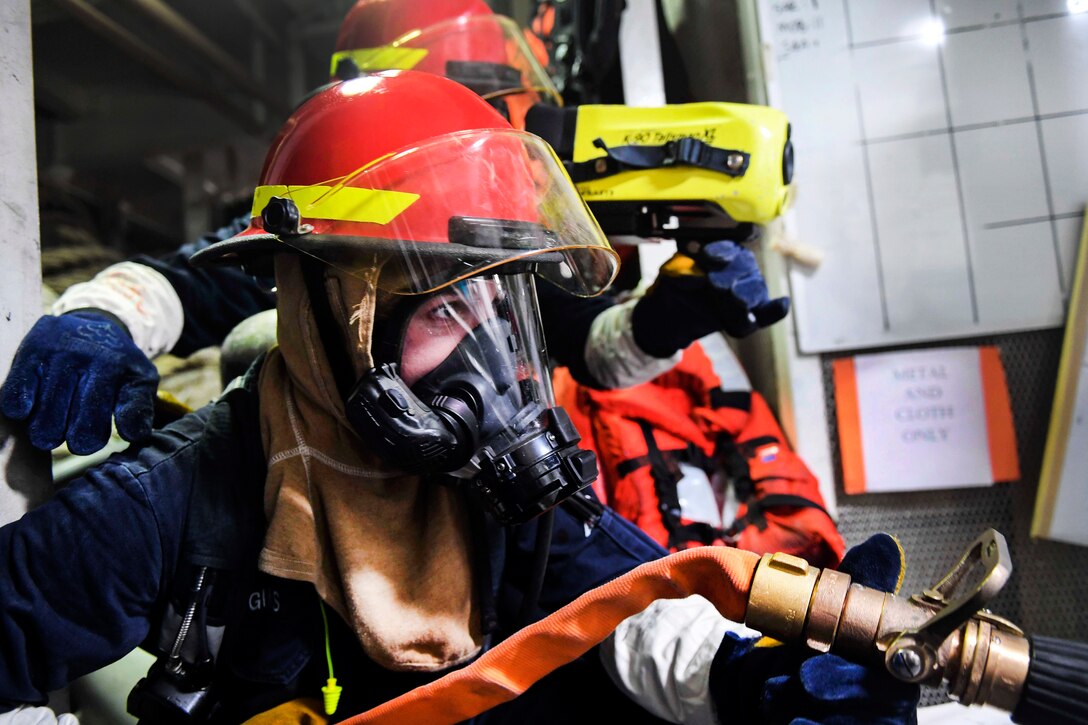 Navy Seaman Nicolas Higgins, foreground, simulates spraying water on a simulated fire while Navy Seaman Ari Rauda uses a thermal imaging system during a fire drill aboard Arleigh Burke-class guided-missile destroyer USS Wayne E. Meyer in the Pacific Ocean, Jan. 25, 2017. Higgins is a machinery repairman fireman and Rauda is a damage controlman fireman. Navy photo by Petty Officer 3rd Class Kelsey L. Adams