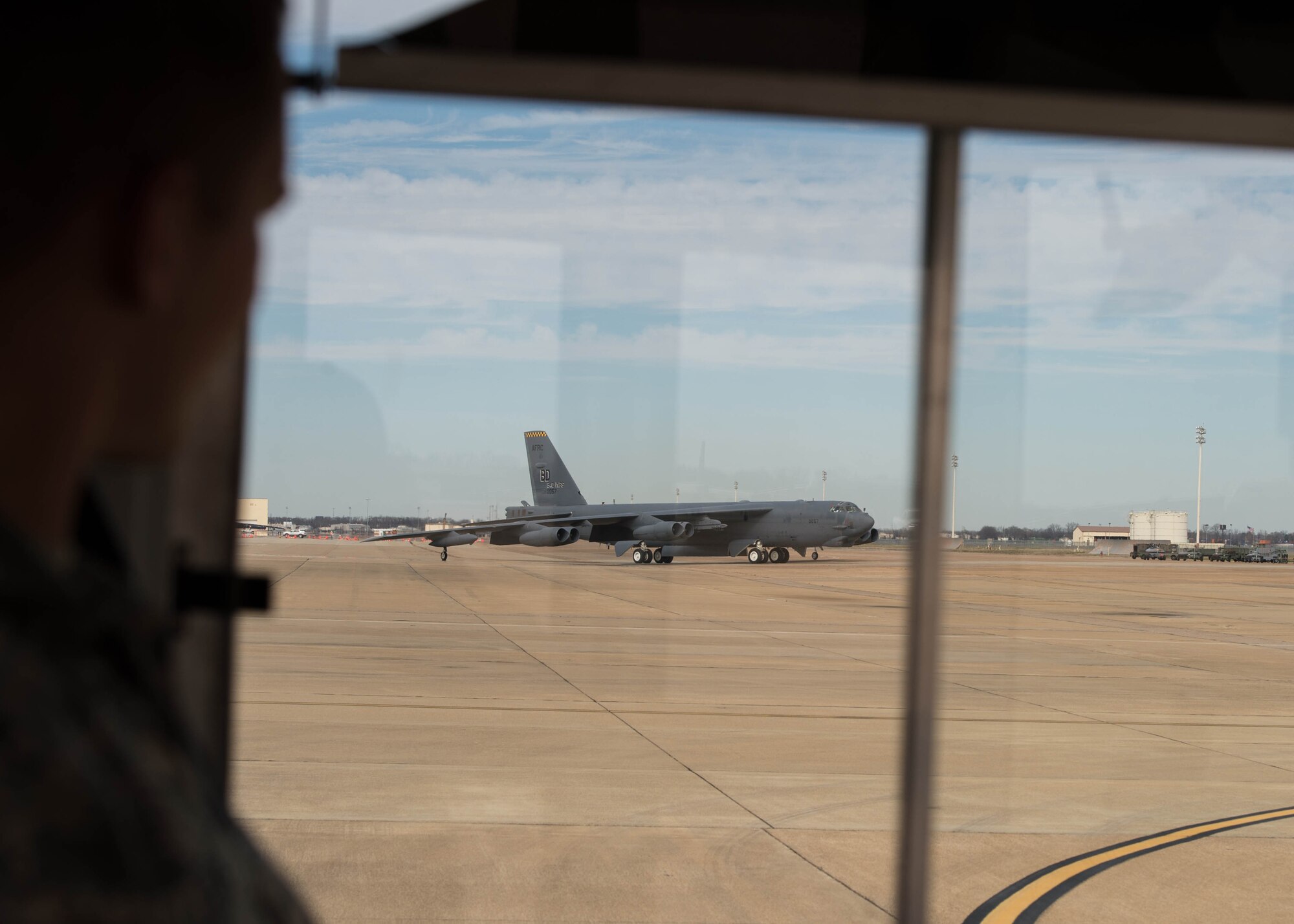 An Airman looks out the window of his bus as a B-52 Stratofortress returns from a routine training mission at Barksdale Air Force Base, La., Jan. 27, 2017.   The flight included two incentive flight participants from the House Armed Services Committee Professional Staff Members. The HASCP staff gained insight into new proposed upgrades to the original eight TF33 Pratt and Whitney engines, and the future long-term capabilities of the more than 60 year old aircraft. (U.S. Air Force photo by Staff Sgt. Jason McCasland/Released)