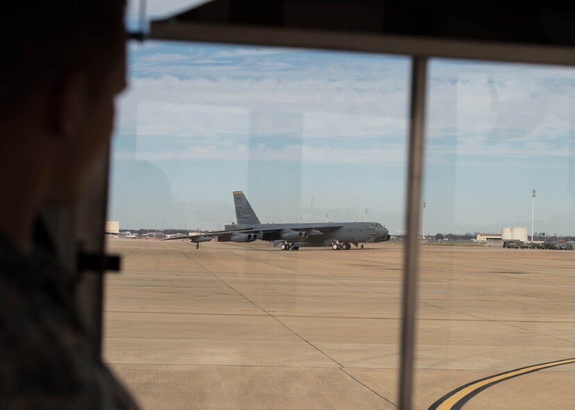 An Airman looks out the window of his bus as a B-52 Stratofortress returns from a routine training mission at Barksdale Air Force Base, La., Jan. 27, 2017.   The flight included two incentive flight participants from the House Armed Services Committee Professional Staff Members. The HASCP staff gained insight into new proposed upgrades to the original eight TF33 Pratt and Whitney engines, and the future long-term capabilities of the more than 60 year old aircraft. (U.S. Air Force photo by Staff Sgt. Jason McCasland/Released)