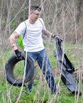 Then-Seaman Apprentice Chris Polizzi collects a tire and other trash from the area around the Salado Creek Park area at Joint Base San Antonio-Fort Sam Houston Saturday during last year’s Basura Bash Feb. 20, 2016. A total of seven tires were found among the almost two tons of trash collected.