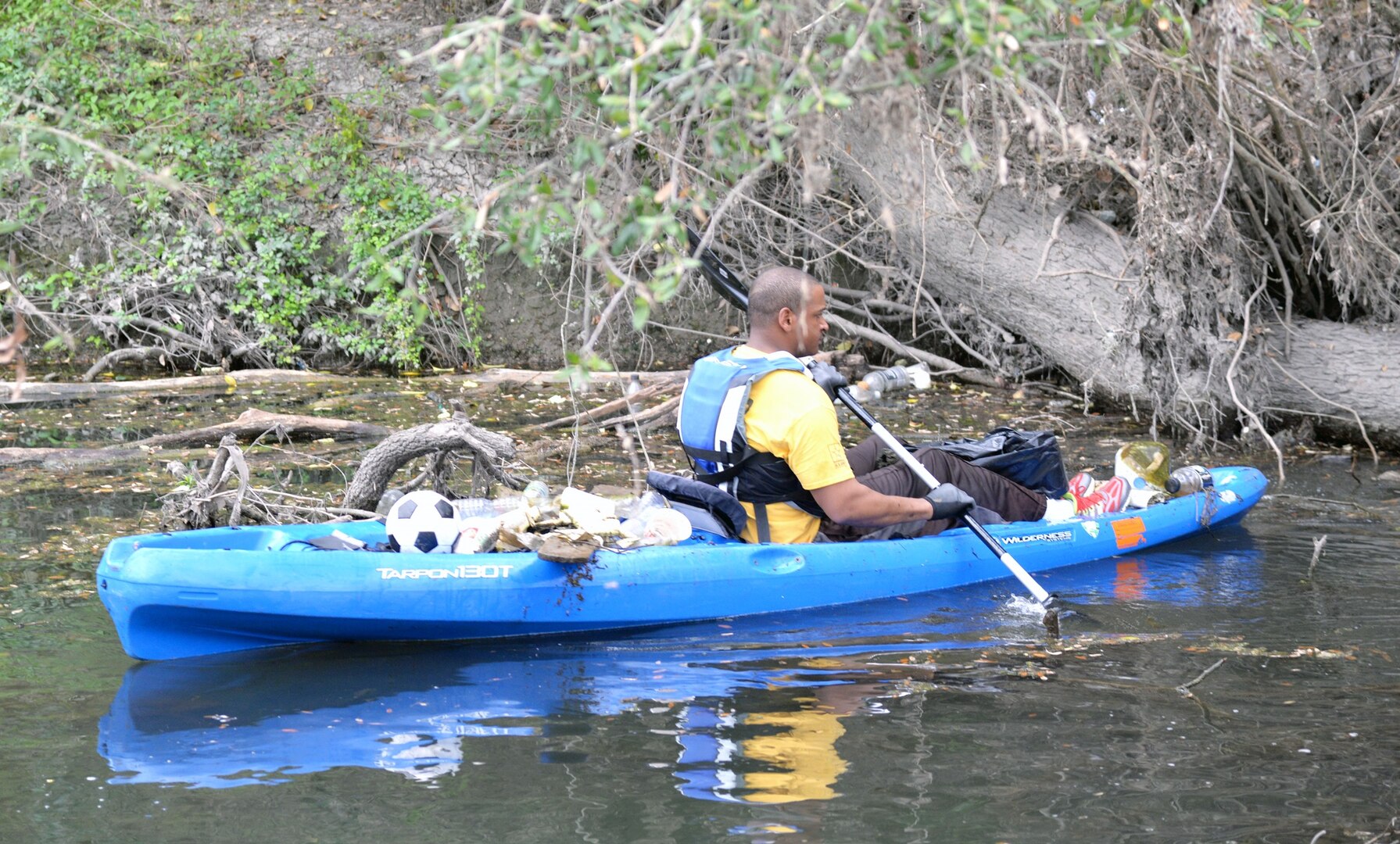 Army Staff Sgt. Sy Smith, an instructor/writer with Company A, Academy Brigade (Provisional), carefully maneuvers a kayak down Salado Creek while picking trash out of the waterway during the annual Basura Bash at Salado Creek Park at Joint Base San Antonio-Fort Sam Houston during last year’s Basura Bash Feb. 20, 2016. The kayaks were provided by JBSA Morale, Welfare and Recreation.