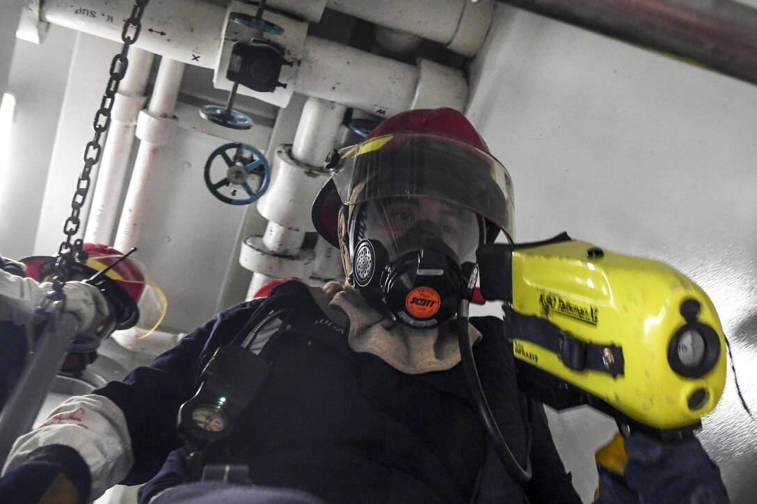 Navy Seaman Ari Rauda carries a thermal imaging system while leading his fire team to an after-action review following a fire drill aboard Arleigh Burke-class guided-missile destroyer USS Wayne E. Meyer in the Pacific Ocean, Jan. 25, 2017. Rauda is a damage controlman fireman. Navy photo by Petty Officer 3rd Class Kelsey L. Adams
