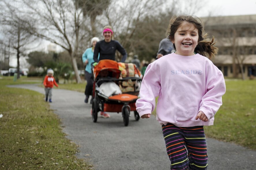 A child leads the way as she and her family complete the Heritage 5k at Hurlburt Field, Fla., Jan. 28, 2017. The 1st Special Operations Force Support Squadron hosts events like this to promote fitness in the Hurlburt community. (U.S. Air Force photo by Airman Dennis Spain)