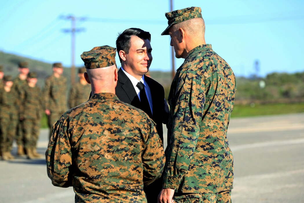 Sgt. Zachary L. Piepenhagen (center), is congratulated by Maj. Gen. David Coffman, deputy commanding general, I Marine Expeditionary Force, after being awarded the Navy and Marine Corps Medal, at Marine Corps Base Camp Pendleton, Calif., Jan. 26, 2017. Piepenhagen was awarded the medal for saving the life of a distressed Sailor who climbed over the guard rail in an attempt to commit suicide while serving with the 13th Marine Expeditionary Unit. (U.S. Marine Corps photo by Private First Class Gabino Perez)