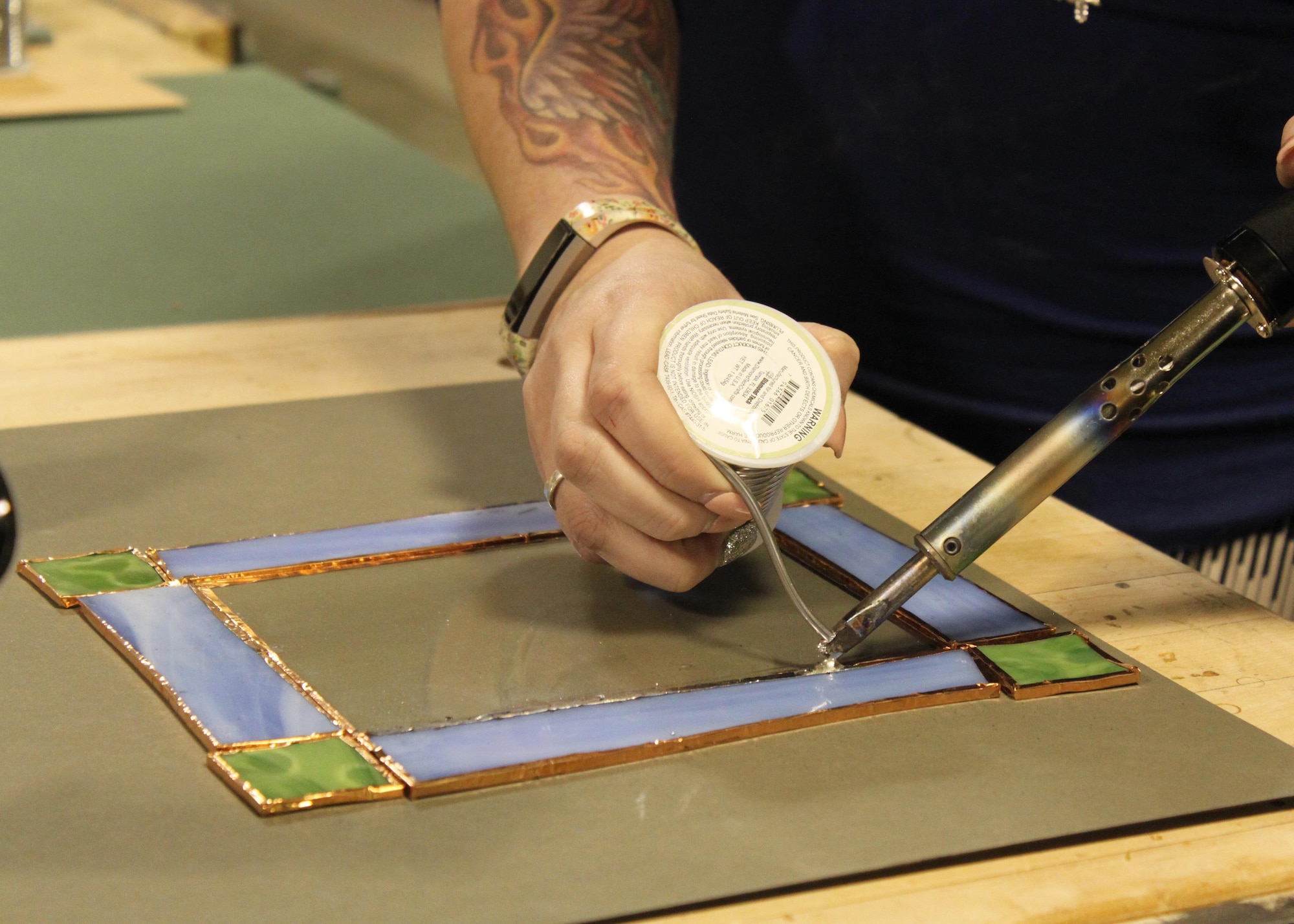 Participants used soldering irons to complete their 5x7 picture frame at the first Stained Glass Class held Jan. 26 at the Arts & Crafts Center. (U.S. Air Force photo by Kayla Fagan)