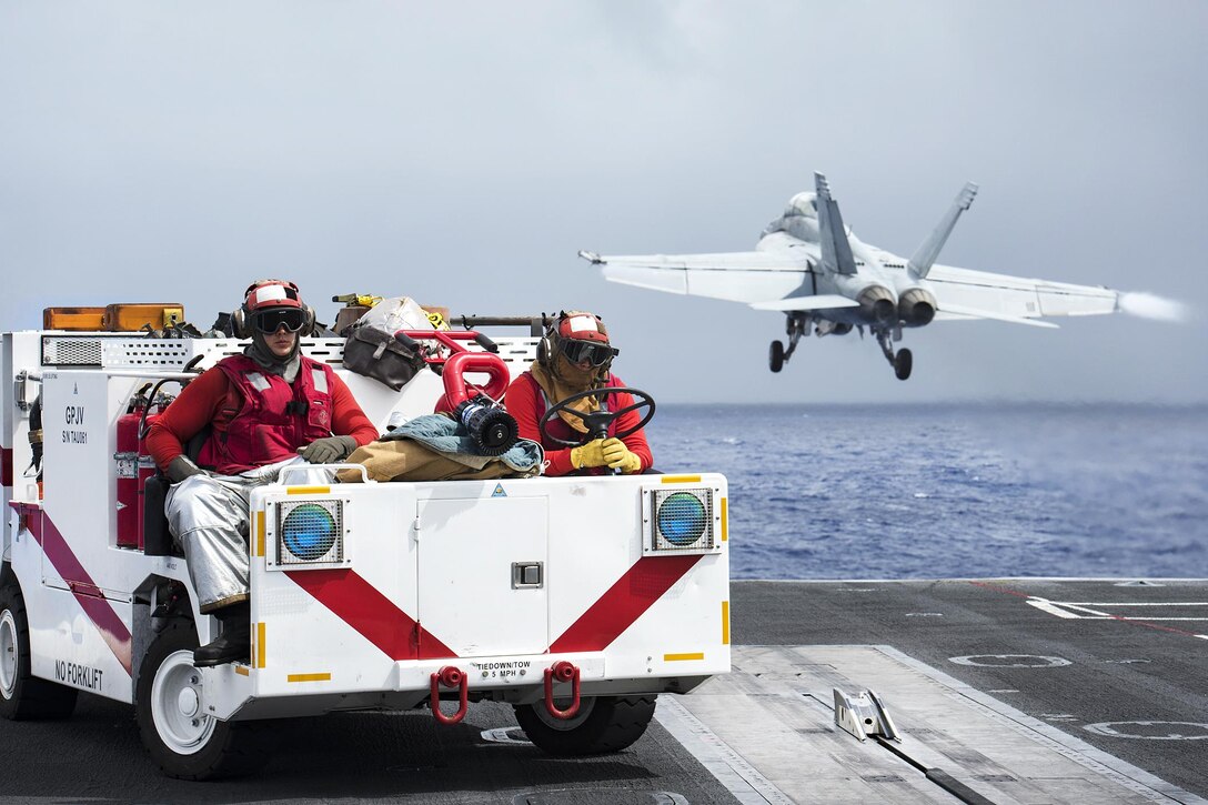 Navy Petty Officer 3rd Class Christopher Baker, left, and Seaman Christopher Guzelli stand by on fire watch on the aircraft carrier USS Carl Vinson in the Pacific Ocean, Jan. 27, 2017. Baker is an aviation boatswain’s mate (handling), and Guzelli is an aviation boatswain’s mate (handling) airman. Navy photo by Seaman Jake Cannady