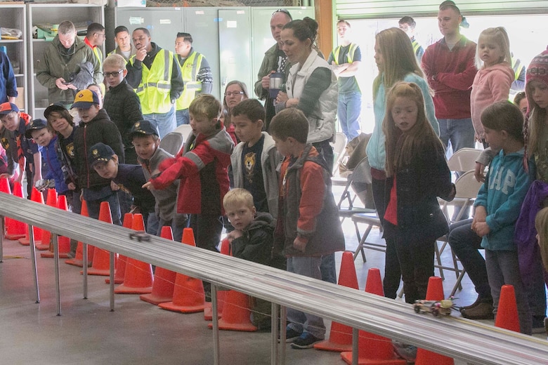 Children with Cub Scout Pack 78 watch as their race cars zoom by them during the annual Cub Scout Pinewood Derby at the Armed Services YMCA Scout Hut, Jan. 21, 2017. (U.S. Marine Corps photo by Cpl. Thomas Mudd)