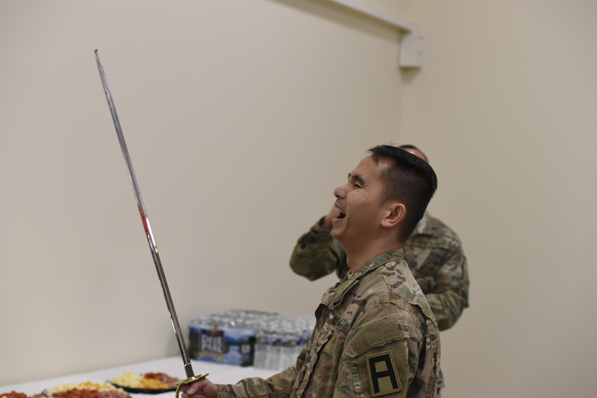 Lt. Col. Binh Nguyen, incoming 3-313th Logistics Support Battalion commander, cuts a cake with a ceremonial sword during the change of command reception at Joint Base McGuire-Dix-Lakehurst, New Jersey, Jan. 28, 2017. Nguyen is replacing Lt. Col. John Turner Jr. as commander of the 3-313th.