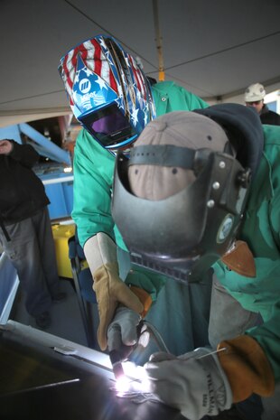 A keel laying and authentication ceremony for the future USS Lyndon B. Johnson (DDG 1002) was held Jan. 30 at General Dynamics-Bath Iron Works shipyard in Bath, Maine.  Lynda Johnson Robb etches her initials into the keel plate with assistance from veteran GD-BIW shipyard welder, Timothy Trask.   