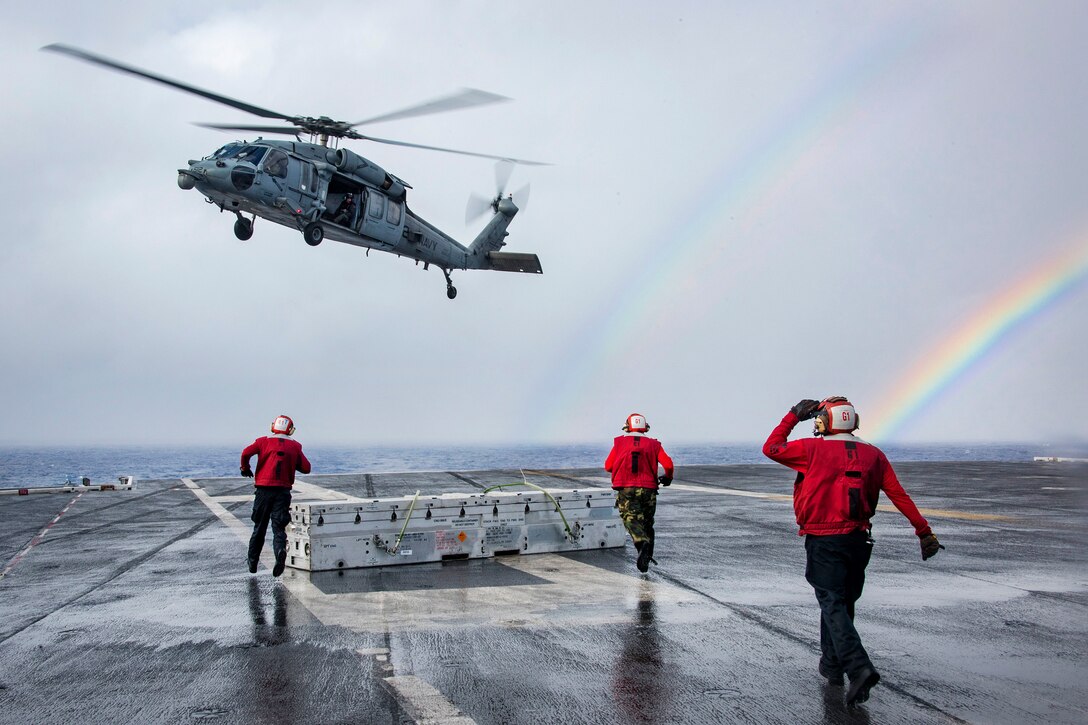 With a double rainbow in the background, sailors run to gather ordnance delivered by an MH-60S Seahawk helicopter during a vertical replenishment with the aircraft carrier USS Carl Vinson and the Military Sealift Command dry cargo and ammunition ship USNS Charles Drew in the Pacific Ocean, Jan. 28, 2017. Navy photo by Petty Officer 2nd Class Sean M. Castellano