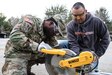Army Warrant Officer Candidate Brian M. Torres, a Vineland, N.J., native who recently entered the warrant officer candidate program while serving in the 143d Sustainment Command (Expeditionary)'s G6 (Communications) section, explains how to operate a chop saw to Army Sgt. Jonathan Bell (left), an Orlando, Fla., native serving as a human resources noncomissioned officer, Headquarters & Headquarters Company, 143d ESC, during a an environmental sustainability community project Jan. 27, 2017, in Orlando, Fla. Bell, Torres and five other Army Reserve Soldiers constructed several wooden garden beds to help revive  Orlando’s Colonialtown North Community Garden to its former, greener glory. Directed by Green Works Orlando in conjunction with the NFL’s Environmental Program, the garden’s revival was one of the many community projects both organizations managed to lighten the environmental footprint produced by the tens of thousands of football fans who have flocked to The City Beautiful to watch the NFL’s first Pro Bowl game to take place in the Continental U.S. since 1979. 