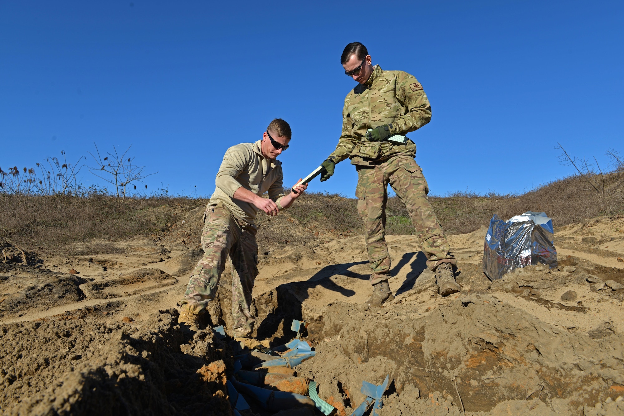 U.S. Air Force Staff Sgt. Andrew Wright, 20th Civil Engineer Squadron explosive ordnance disposal equipment section chief, left, and Senior Airman Tyler McMillan Wammack, 20th CES EOD journeyman, right, lay down C-4 explosives on top of bomb dummy unit (BDU) 33s at Poinsett Electronic Combat Range, Wedgefield, S.C., Jan. 25, 2017. The EOD Airmen used approximately 75 pounds of C-4 to destroy BDU munitions, which are training munitions used by 20th Fighter Wing pilots to maintain readiness. (U.S. Air Force photo by Airman 1st Class Destinee Sweeney)