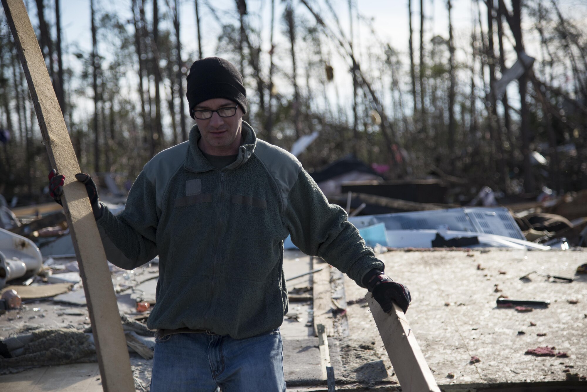 A Moody Air Force Base Airman carries salvageable wood away from piles of debris left in the wake of a tornado, Jan. 28, 2017, in Adel, Ga. The tornado killed 15 people and was later deemed an EF3, the strongest tornado to touch down in the county’s history. (U.S. Air Force photo by 2d Lt. Kaitlin Toner)