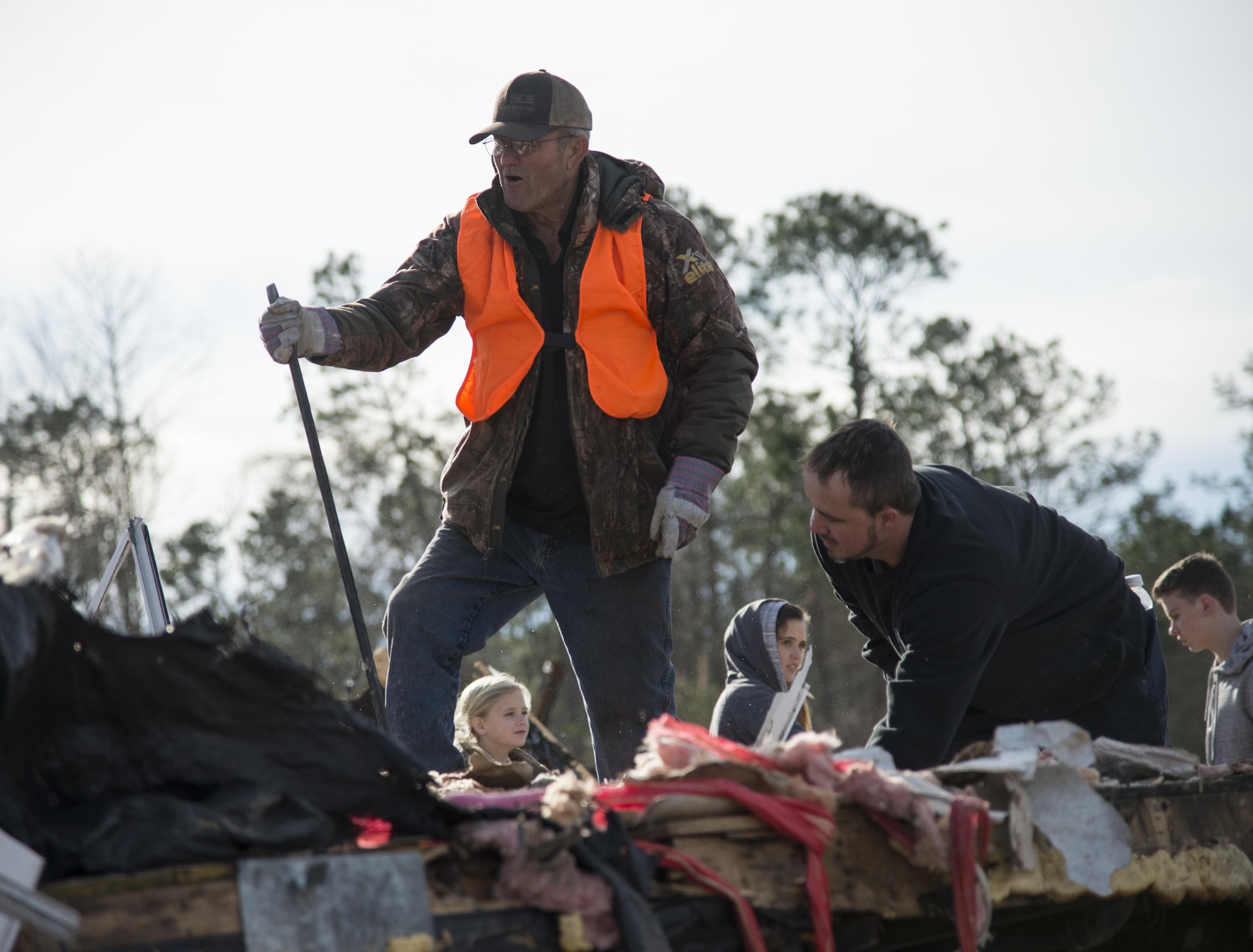 A volunteer climbs to the top of a pile of debris left in the wake of a tornado, Jan. 28, 2017, in Adel, Ga. The tornado killed 15 people and was later deemed an EF3, the strongest tornado to touch down in the county’s history. (U.S. Air Force photo by 2d Lt. Kaitlin Toner)