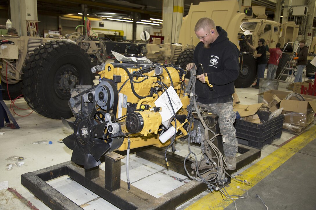 Dustin Wiley, originally from Riverside, Calif., and a wheeled mechanic at Production Plant Barstow, Marine Depot Maintenance Command, works on the engine that powers the Mine Resistant Ambush Protected All Terrain Vehicles, or M-ATV, currently being repaired and upgraded at the Plant Jan. 12. Wiley is a former Army National Guardsman who served in Afghanistan as a mechanic. He said he has driven and worked on the M-ATVs and knows the heavily built troops transports save lives.