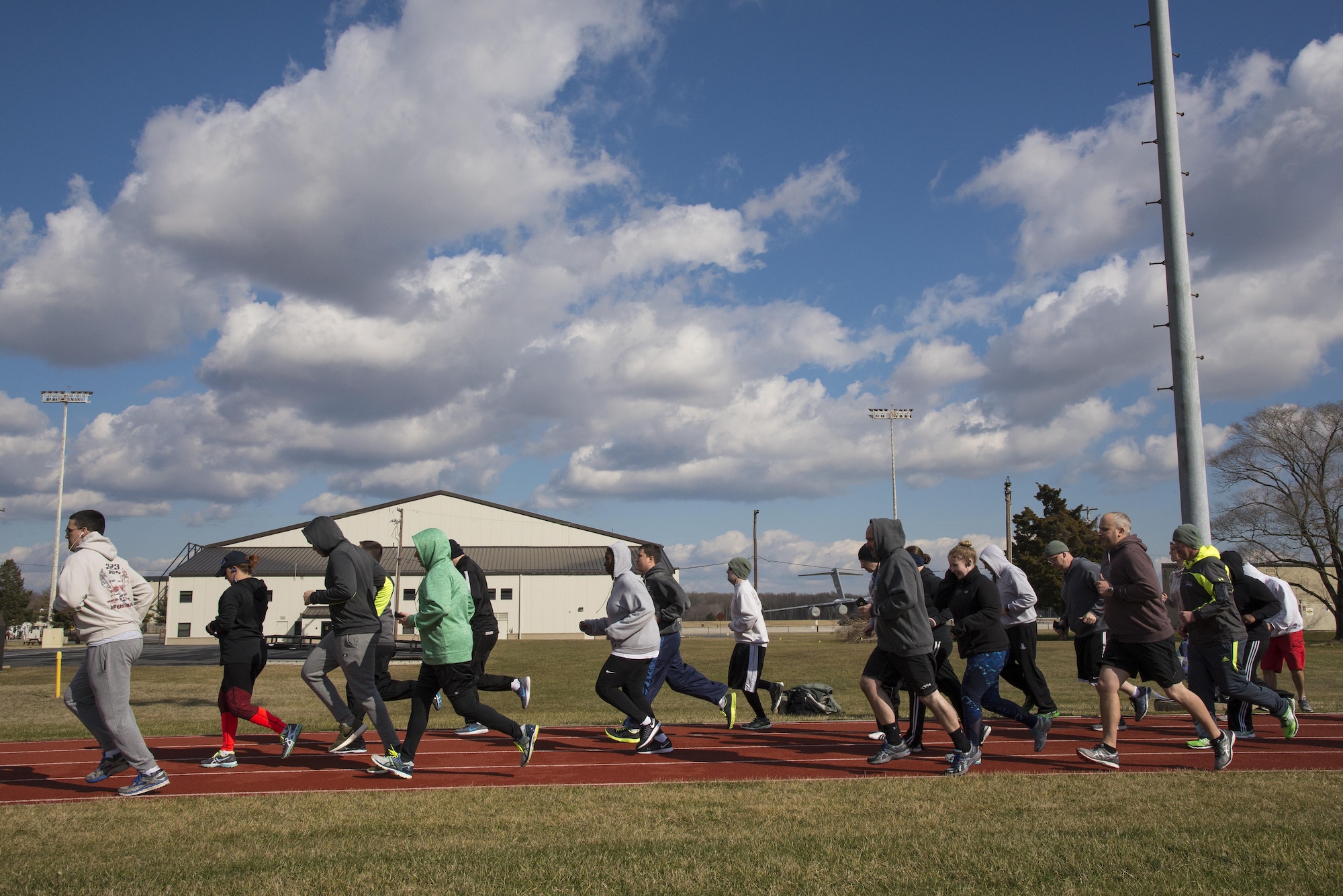 Members of Team Dover run a warmup lap Jan 30, 2017, during a 90 Plus class at the track on Dover Air Force Base, Del. Each high-intensity class only lasts about 20 to 30 minutes, and focuses on improving performance in each area of the fitness assessment. (U.S. Air Force photo by Senior Airman Aaron J. Jenne)