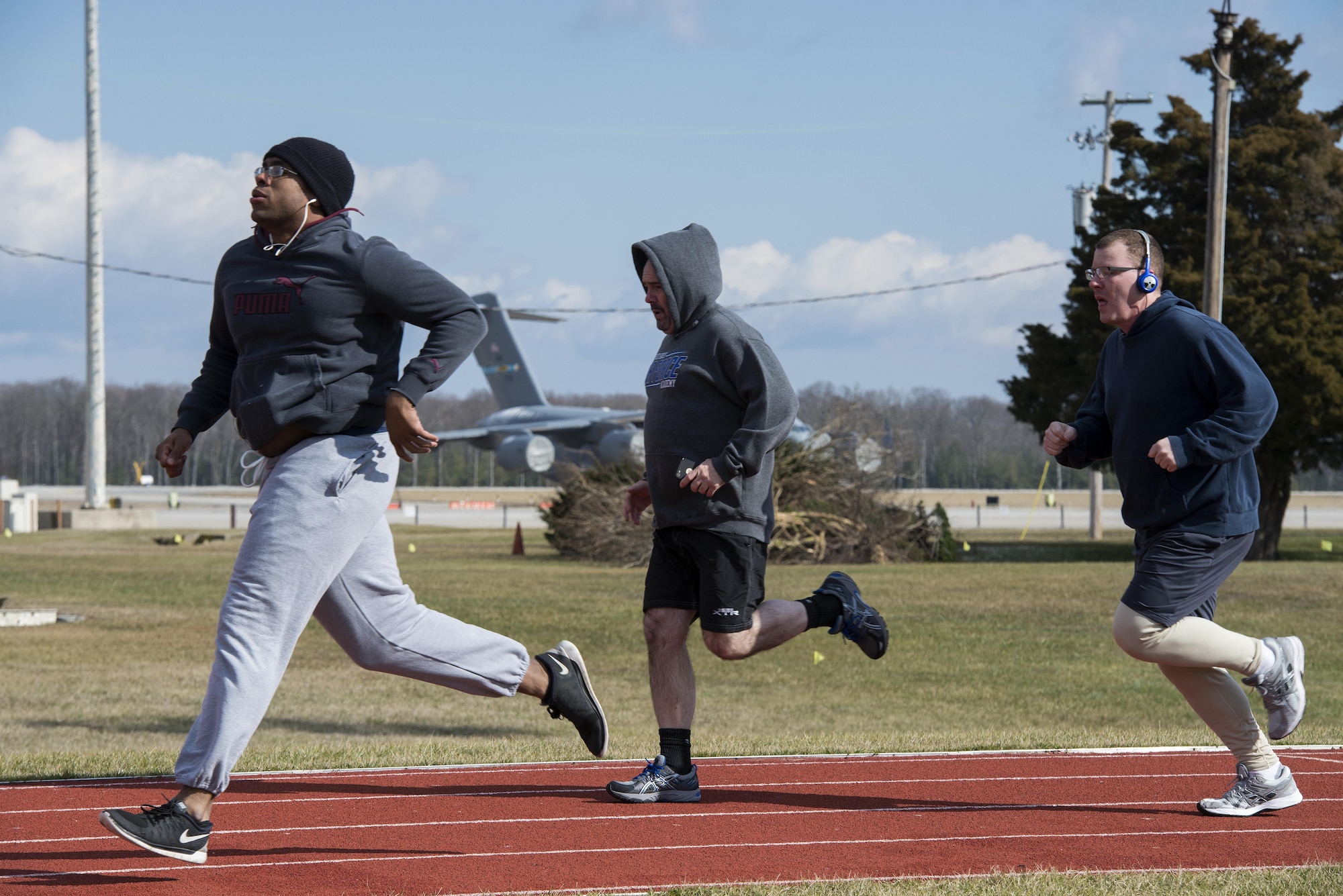 Members of Team Dover sprint the straightaway during a 90 Plus class, hosted by the fitness center, Jan. 30, 2017, at the track on Dover Air Force Base, Del. The Fitness center leads more than 150 free classes each month, including 90 Plus, TS-24, TRX and Extreme Fitness. (U.S. Air Force photo by Senior Airman Aaron J. Jenne)