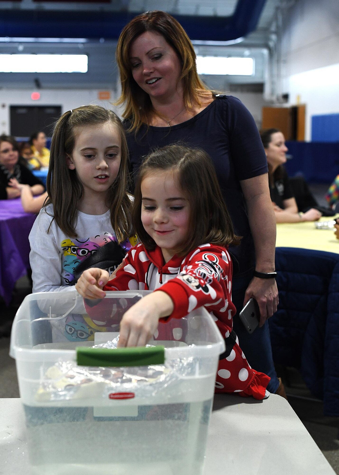 Holly Ruzich and her daughters Gianna, 8, left, and Carmen, 6, test the buoyancy of their boat Jan. 28, 2017, on Grand Forks Air Force Base, N.D. Members of the University Of North Dakota Society Of Women Engineers visited Grand Forks AFB to educate mothers and daughter in the Science, Technology, Engineering and Math fields. (U.S. Air Force photo by Senior Airman Sparks)