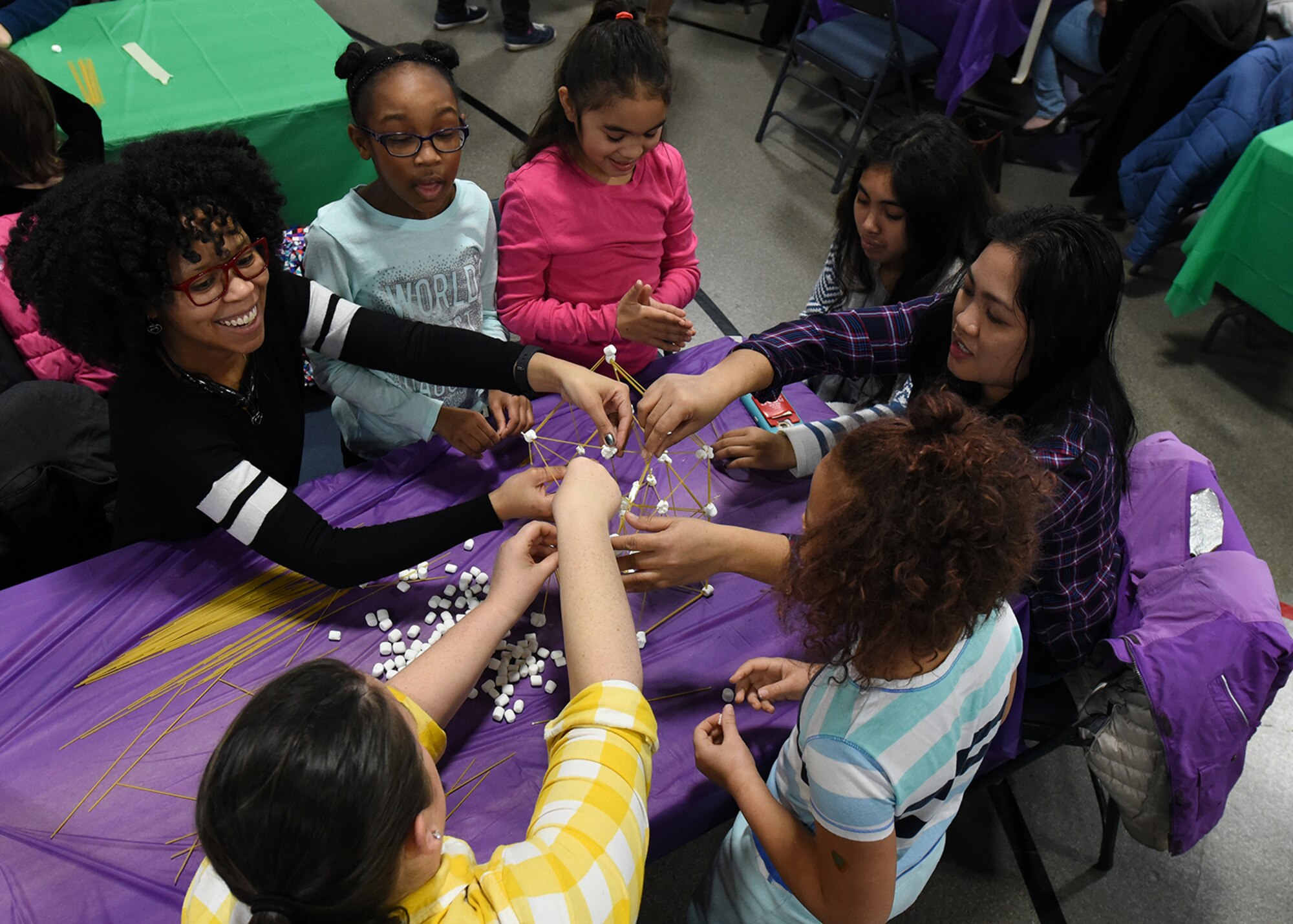 A group of mothers and daughters team up to build the tallest structure Jan. 28, 2017, on Grand Forks Air Force Base, N.D. The 319th Air Base Wing School Liaison Office hosted a Science, Technology, Engineering and Math event to help foster interest in the STEM field among young women. (U.S. Air Force photo by Senior Airman Sparks)