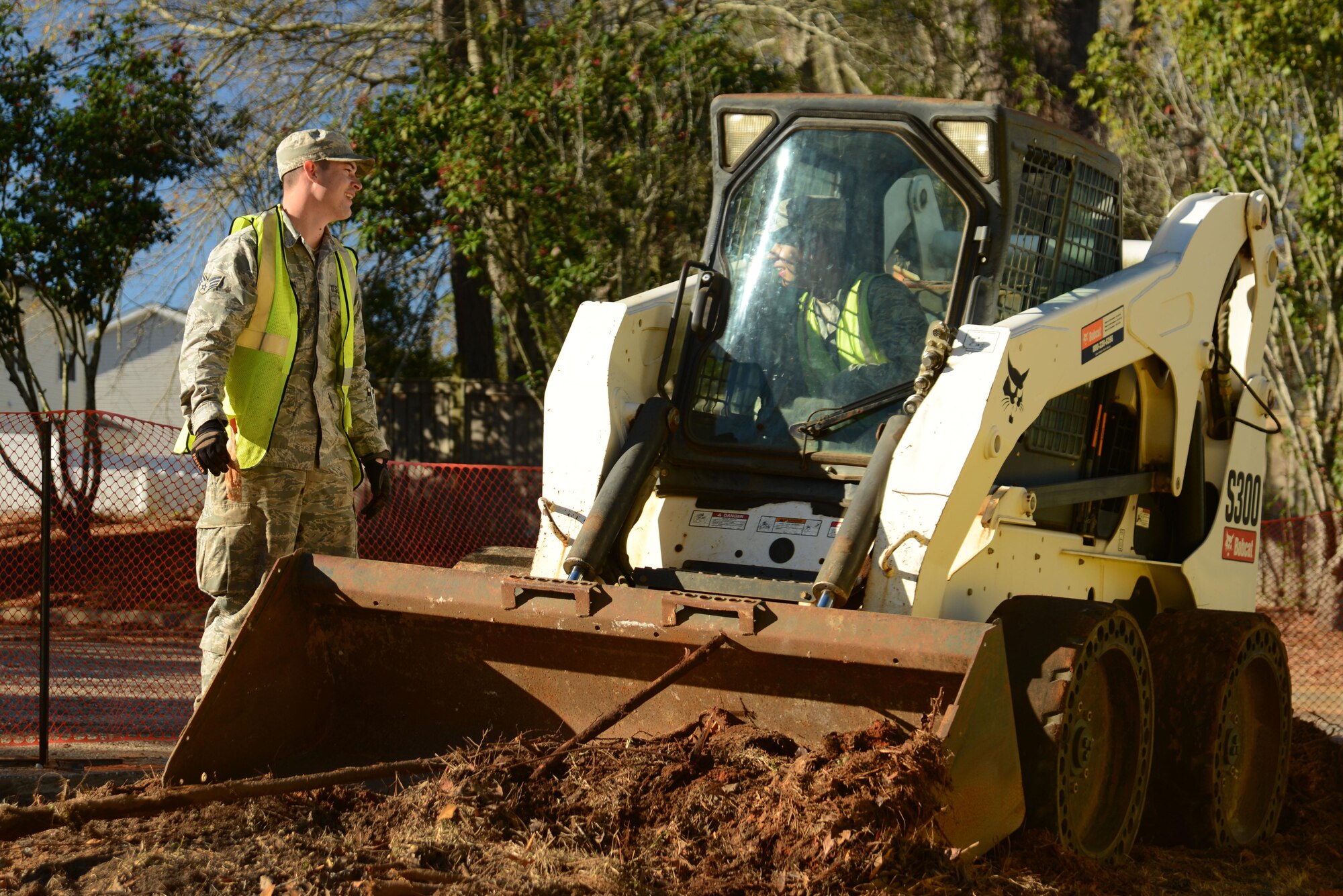 U.S. Air Force Senior Airman Jacob Robinson, left, and Airman 1st Class Cesar Cortes-Sanchez, right, 20th Civil Engineer Squadron pavements and construction journeymen, converse at Shaw Air Force Base, S.C., Jan. 25, 2017. The Airmen, also known as Dirt Boyz, used a skid-steer loader to remove excess dirt after the removal of a traffic island, expanding a parking lot to accommodate fire trucks at the developing fire station project. (U.S. Air Force photo by Airman 1st Class Kathryn R.C. Reaves)