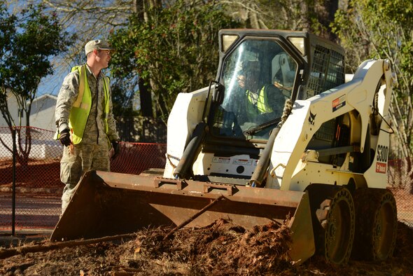 U.S. Air Force Senior Airman Jacob Robinson, left, and Airman 1st Class Cesar Cortes-Sanchez, right, 20th Civil Engineer Squadron pavements and construction journeymen, converse at Shaw Air Force Base, S.C., Jan. 25, 2017. The Airmen, also known as Dirt Boyz, used a skid-steer loader to remove excess dirt after the removal of a traffic island, expanding a parking lot to accommodate fire trucks at the developing fire station project. (U.S. Air Force photo by Airman 1st Class Kathryn R.C. Reaves)