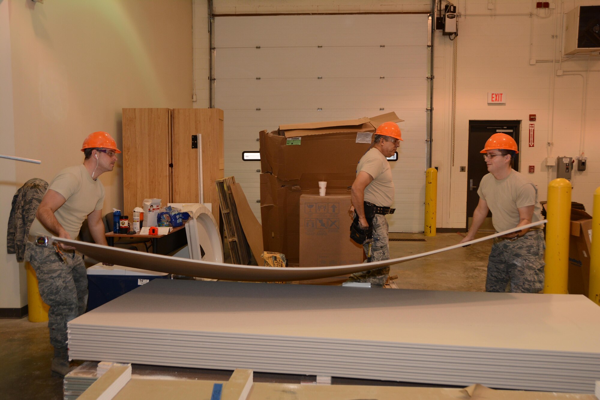 Staff Sgt. Jeremiah Terry and Senior Airman Hunter Conatser of the 507th Civil Engineer Squadron lift a sheet of drywall to be installed in the new emergency communications center Jan. 19, 2016, at Tinker Air Force Base, Okla. The original bid for the facility was upwards of $6 million, but due to limited facility project funds, the 72nd Mission Support Group and the 507th Mission Support Group collaborated to combine the manpower of the 507th CES and the materials of the 72nd MSG.(U.S. Air Force photo/Tech. Sgt Lauren Gleason)