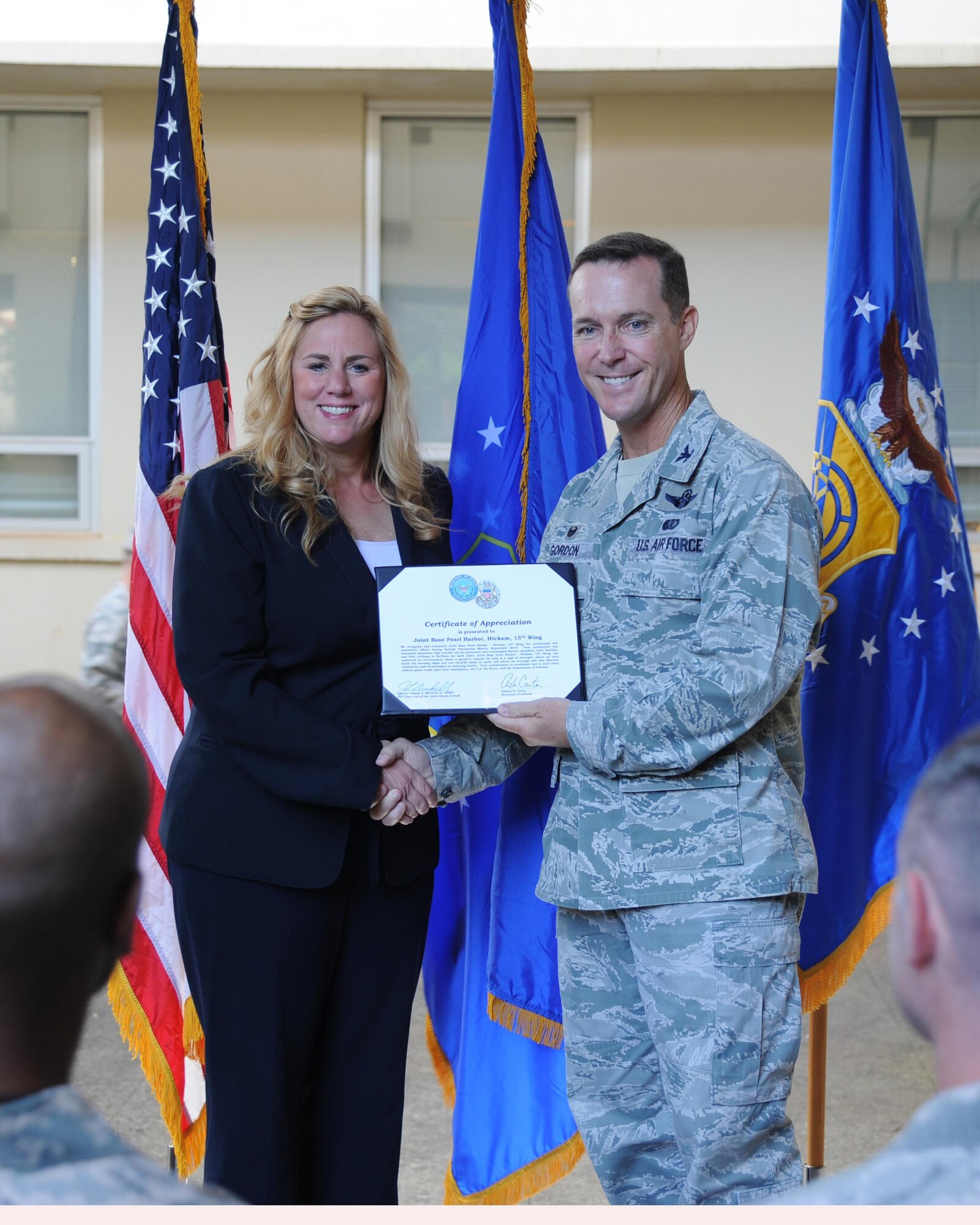 Col. Kevin Gordon, 15th Wing commander, accepts a certificate of appreciation from Dr. Keita Franklin, Defense Suicide Prevention Office director, on behalf of the Hickam Mental Health Clinic at Joint Base Pearl Harbor-Hickam, Hawaii, Jan. 30, 2017. The 15th Wing clinic was recognized for its superior efforts to prevent suicide in Sept. 2016. (U.S. Air Force photo by 1st Lt. Kaitlin Daddona/Released)