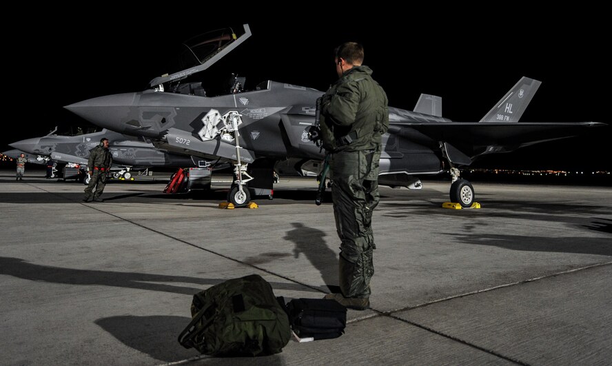 A pilot assigned to the 388th Fighter Wing, Hill Air Force Base, Utah, stands by an F-35A as preflight checks are performed before a night operation Red Flag 17-1 on Nellis Air Force Base, Nev., Jan. 24, 2017. This is the first time that F-35A crews integrate with other airframes during a Red Flag exercise. (U.S. Air Force photo by Airman 1st Class Kevin Tanenbaum/Released)