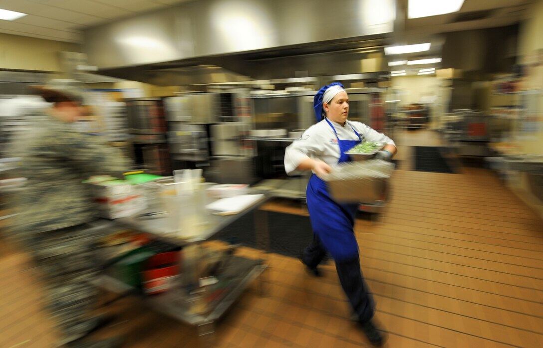 Senior Airman Amanda Williams, a food service journeyman assigned to the 28th Force Support Squadron brings out vegetables to be put out on the line during the lunch rush at Ellsworth Air Force Base, S.D., Oct. 6, 2017. Each year, dining facilities across the different major commands compete for the John L. Hennessy award, which recognizes the best DFAC in each command. Once the finalists from each MAJCOM are chosen, they then compete at the Air Force level. (U.S. Air Force photo by Airman 1st Class Randahl J. Jenson)