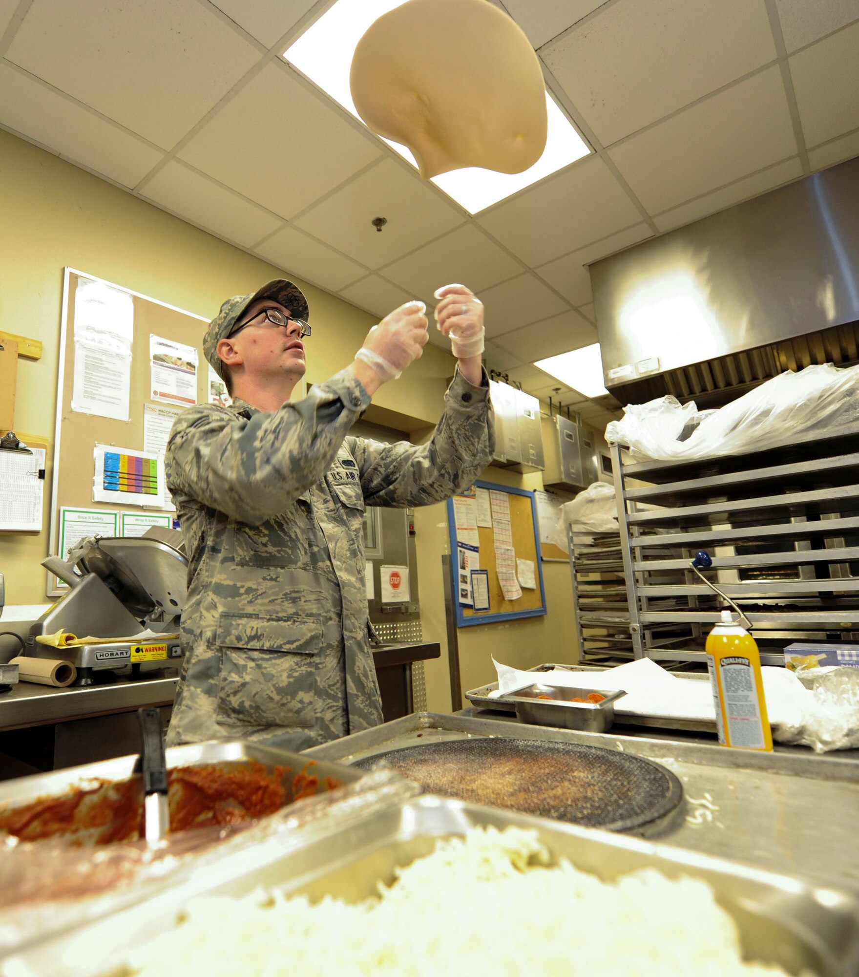 Senior Airman Boyd Cox, a food service journeyman assigned to the 28th Force Support Squadron tosses pizza dough in the air to prepare for the lunch rush at Ellsworth Air Force Base, S.D., Oct. 6, 2016. The Raider Café, Ellsworth’s dining facility, was recently nominated for the coveted John L. Hennessy award at the major command level, and will soon compete at the Air Force level within the next month. (U.S. Air Force photo by Airman 1st Class Randahl J. Jenson)