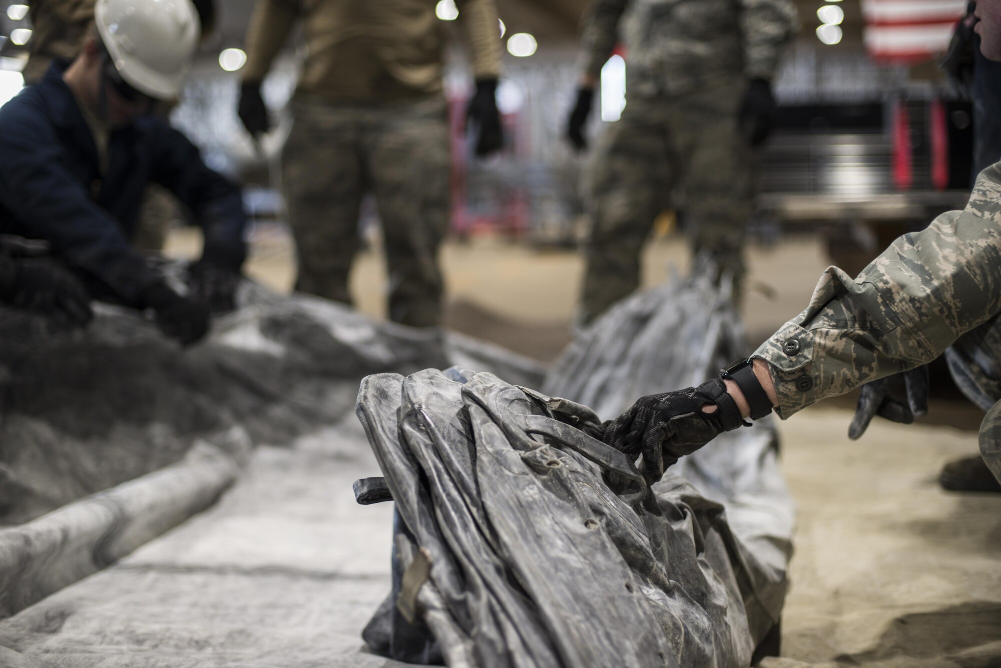 Airmen with the 35th Maintenance Squadron crashed, damaged, disabled aircraft recovery unit inspect a lifting bag at Misawa Air Base, Japan, Jan. 28, 2017. CDDAR conducts training annually to ensure Airmen stay proficient in case of a real-world aircraft emergency. Lifting bags are used to elevate an aircraft approximately 18 inches off the ground, enabling the landing gear to be dislodged. (U.S. Air Force photo by Senior Airman Brittany A. Chase)