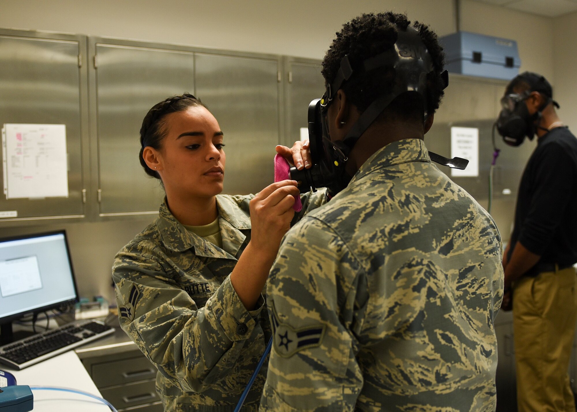 U.S Air Force Airman 1st Class Dannyel Butte, 325th Aerospace Medicine Squadron bioenvironmental engineer apprentice, assists Airman 1st Class Dorothy Russell, 325th Aerospace Medicine Squadron bioenvironmental engineer apprentice, with her gas mask fit test at the 325th Medical Group Clinic on Tyndall Air Force Base, Fla., Jan. 25, 2017. Bioenvironmental engineers help protect Airmen and their families from environmental and occupation hazards, preventing and controlling the spread of disease, and safeguarding the physical and mental wellbeing patients. (U.S. Air Force photo by Senior Airman Dustin Mullen/Released)