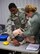 Staff Sergeant Cortney Jumper, 932nd Aeromedical Staging Squadron (ASTS), picks up pieces of equipment as he prepares to practice giving first aid to the simulated patient in a skills refresher class January 7, 2017.  The course included Cardio Pulmonary Resuscitation (CPR) skills, which can help save a life during a cardiac or breathing emergency. The course featured feedback from the electronic 