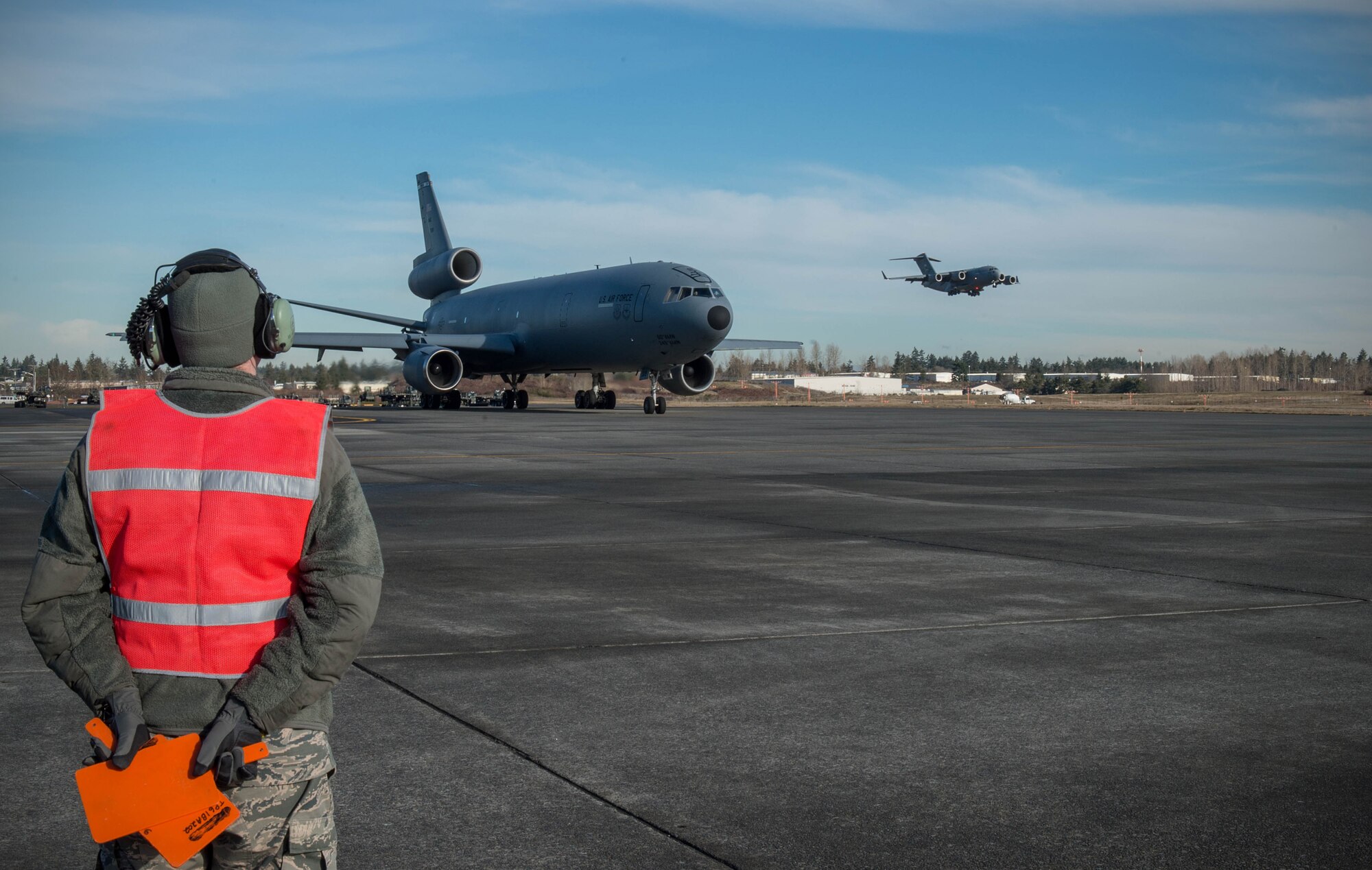 Senior Airman William Roten, 821st Contingency Response Squadron maintainer, prepares to marshal a KC-10 Extender aircraft from Travis Air Force Base, Calif., Jan. 23, 2017, at Joint Base Lewis-McChord, Washington. Airmen from the 821st Contingency Response Group, exercised their capability to support humanitarian efforts during exercise Dragon Breath at JBLM and Fairchild Air Force Base. (U.S. Air Force photo by Staff Sgt. Robert Hicks)