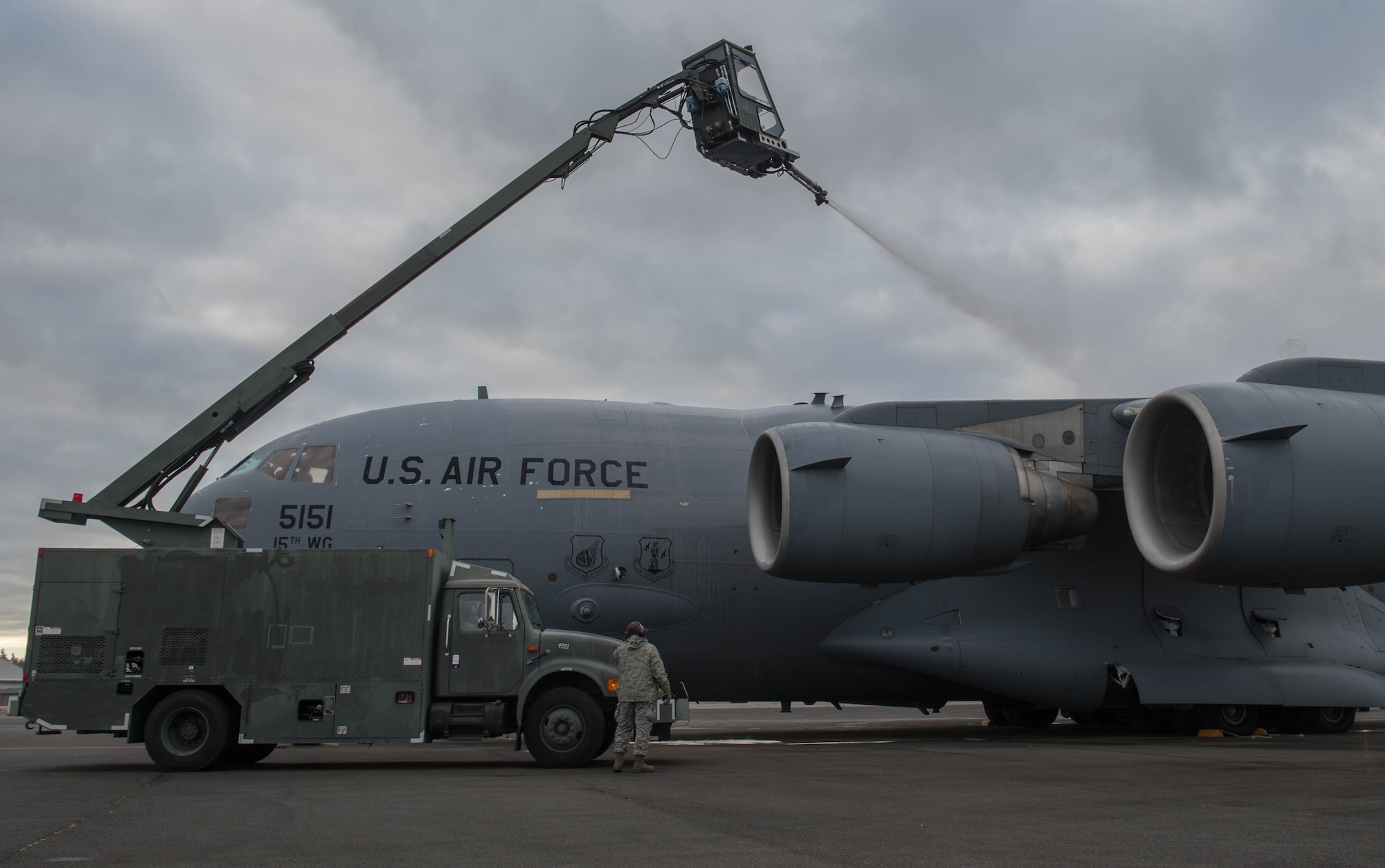 Maintainers from the 821st Contingency Response Group, deice a C-17 Globemaster III aircraft from Joint Base Pearl Harbor-Hickam, Hawaii, before taking off, Jan. 24, 2017, at Joint Base Lewis-McChord, Washington. With temperatures well below freezing the deicer is used to provide protection of aircraft surfaces, engines and aircraft sensors from the elements. (U.S. Air Force photo by Staff Sgt. Robert Hicks)